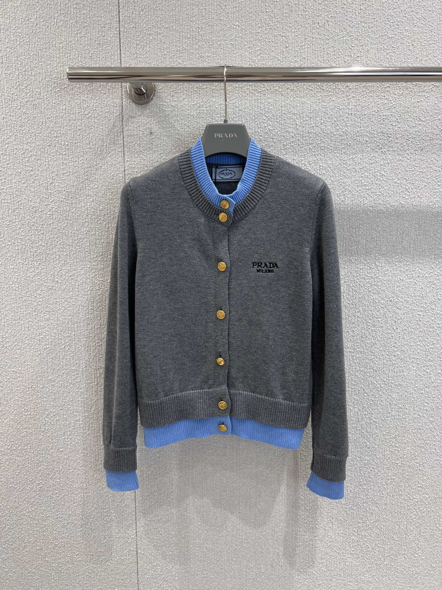 NO:488142,Support for replacement Prad* 25Fw early autumn new style, letter embroidered single row gold button fake two-piece knitted cardigan | Exclusive high-end product!  Light gray is the main color, paired with fresh blue edges, and the colors collide to create an elegant style. The exquisite golden buttons are the finishing touch, showing the luxury texture of the brand. The knitted fabric is soft and skin-friendly, fits the body without losing comfort. The classic cardigan style is very convenient for daily wear. Whether it is inner or single wear, it can easily create a high-end style. It is suitable for a variety of occasions to add elegance and fashion to the outfit~ S/M/L real-life details pictures, prada, alexander wang19860909支持换款 Prad* 25Fw早秋新款 字母刺绣单排金扣假两件针织开衫丨独家高版出品！以浅灰为主色调,搭配清新蓝边,色彩碰撞出雅致格调.精致的金色纽扣,是点睛之笔,尽显品牌奢华质感.针织面料柔软亲肤,贴合身形又不失舒适.经典的开衫版型,日常穿脱超方便,无论是内搭还是单穿,都能轻松打造出高级感满满的造型,适配多种场合,为穿搭增添优雅与时尚气息～现货发售S/M/L实拍细节图,,prada,alexander wang,Women's clothing