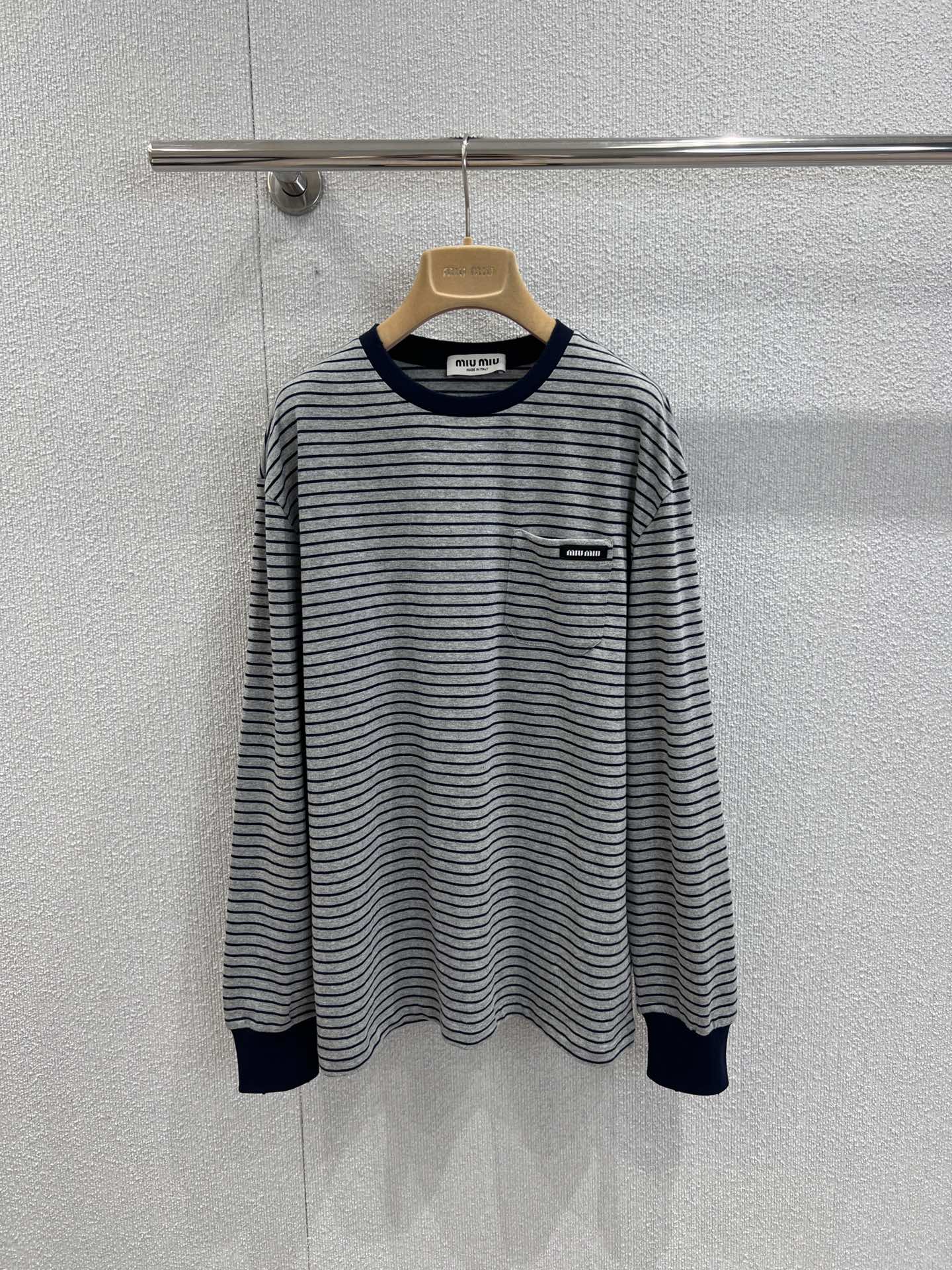 NO:496389,Support replacement MiuMi* 25FW early autumn new model, basic narrow stripes, logo long-sleeved T-shirt丨Exclusive yb development!  High-end production!  With the gray-bottomed pinstripes as the core, the retro academy style is coming to the face; the neckline and cuffs are embellished with hidden blue ribs, which are neat and layered. The black-bottomed white-lined small logo on the left chest is low-key to show the brand identity. The pure cotton fabric is soft and skin-friendly, and the loose shoulder-loose style is highly inclusive for the figure, truly achieving the same style as men and women. The precise striped alignment process takes time and materials, and restores the exquisite texture of the brand from the details. It can be adapted from single-piece stacking or commuting leisure. It can be called the 'evergreen basic style' in the four-season wardrobe. S/M/L real-time detailed pictures are available in stock, miumiu, alexander wang19860909支持换款 MiuMi* 25FW早秋新款 基础款窄条纹 logo长袖 T 恤丨独家yb开发！高版出品！以灰底藏蓝细条纹为核心,复古学院风扑面而来；领口与袖口点缀藏蓝罗纹,利落又具层次感.左胸处黑底白字小标低调彰显品牌身份, 纯棉面料柔软亲肤,宽松落肩版型对身材包容性极强,真正实现男女同款百搭.条纹精准对位工艺耗时费料,从细节处还原品牌精致质感,无论是单穿叠搭还是通勤休闲都能适配,堪称四季衣橱里的“常青基础款”.现货发售S/M/L实拍细节图,,miumiu,alexander wang,Women's clothing