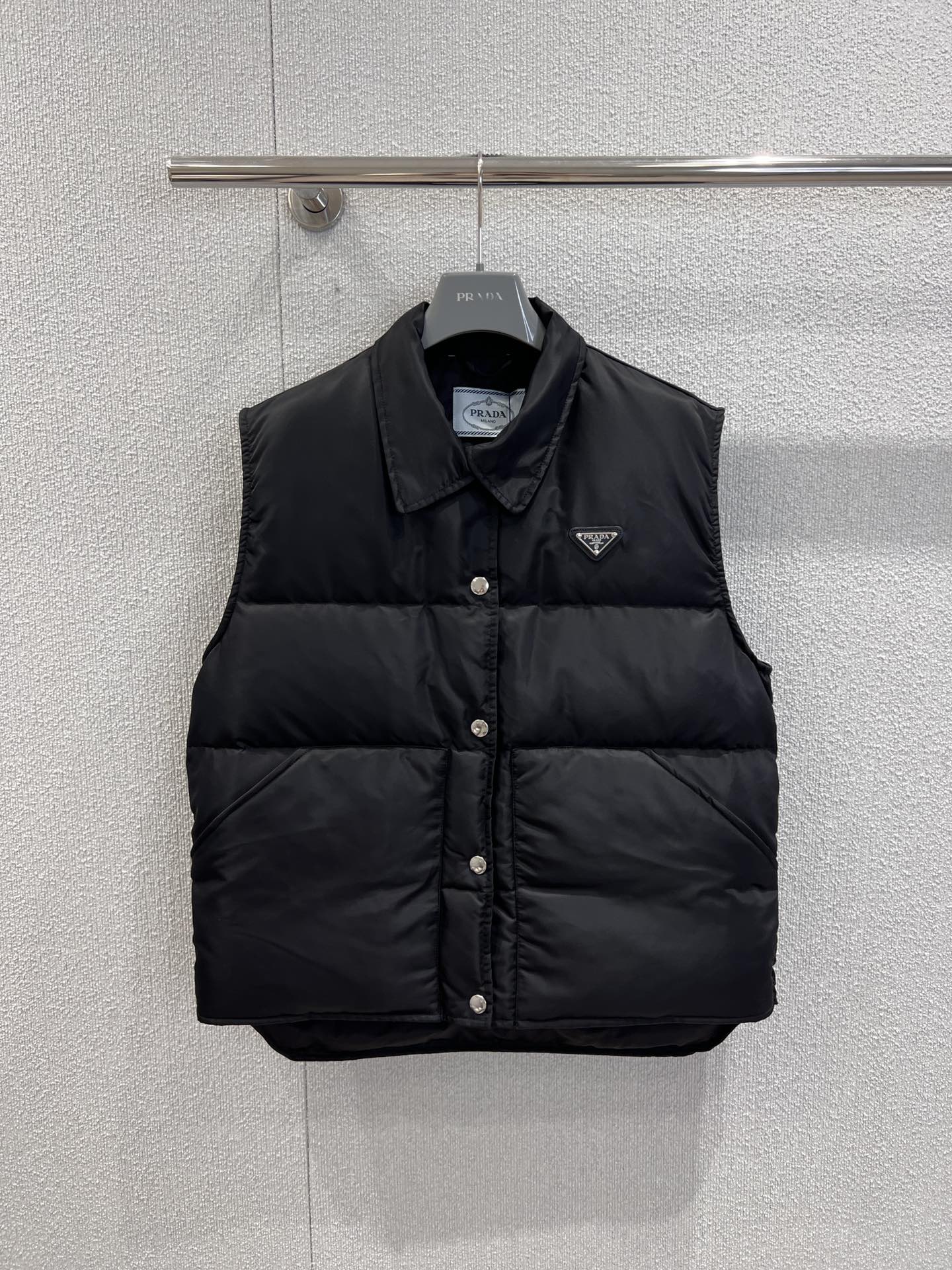 NO:504083,With dust bag Prad* 25Fw early autumn new style, triangle micro-label down vest vest | Exclusive high-end production!  Made of the brand's iconic recycled nylon fabric, the black main tone is high-end and versatile, combining texture and sustainability. The lapel design is neat and stylish, breaking the heavy feeling of down items; the metal buttons on the front are arranged in a regular manner, paired with the iconic triangular logo, instantly pointing out the brand identity, which is a dual embodiment of luxury and recognition. S/M/L real-life details pictures, prada, down jacket, alexander wang19860909配防尘袋 Prad* 25Fw早秋新款 三角微标羽绒背心马甲丨独家高版出品！以品牌标志性的再生尼龙面料打造,黑色主调高级百搭,兼具质感与可持续性.采用翻领设计,利落有型,打破了羽绒单品的厚重感；正面的金属按扣排列规整,搭配标志性的三角徽标,瞬间点明品牌身份,是奢华与辨识度的双重体现.现货发售S/M/L实拍细节图,,prada,down jacket,alexander wang,Women's clothing