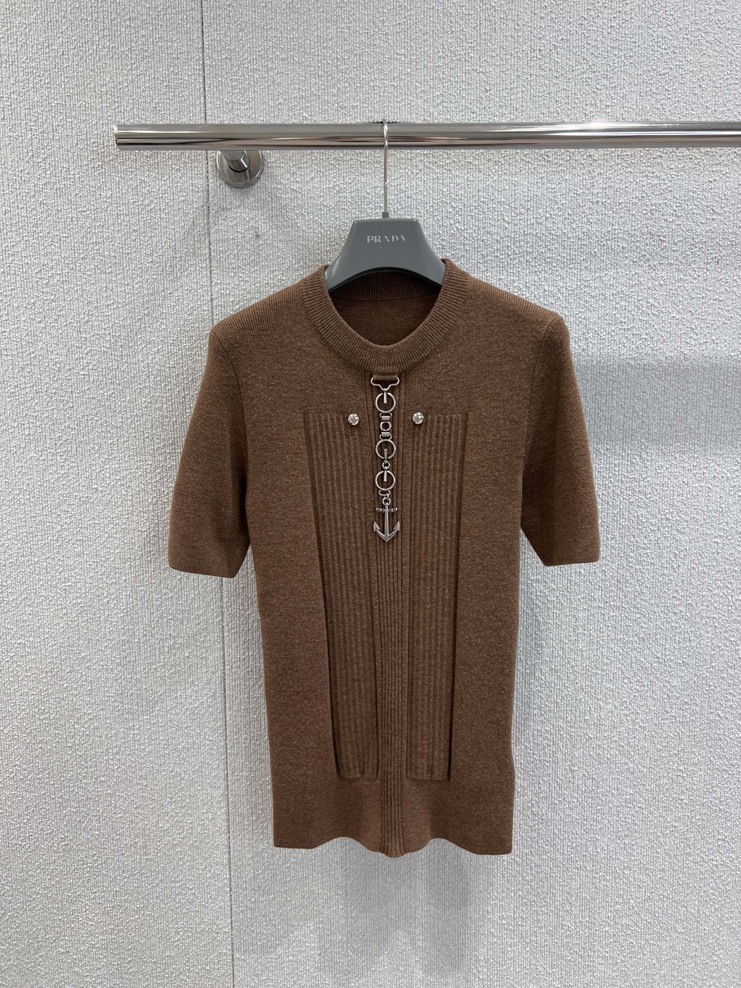 NO:506222,Support replacement Prad* 25Fw early autumn new style, brown pendant short-sleeved sweater丨Exclusive yb development!  High-end production!  The delicate knitted warm and brown color is the base, and the close-fitting cut out the neat sense of the body lines; the metal chain on the chest and the anchor pendant are the finishing touch. The iconic hardware elements collide with navigation symbols, making the brand's obsession with industrial style and retro romanticism into hardcore details, allowing a sweater to jump out of the mediocrity of the 'basic style' and become the visual anchor point of the shape. S/M/L real-life details pictures, prada, T-shirt, alexander wang19860909支持换款 Prad* 25Fw早秋新款 咖色吊坠短袖针织衫丨独家yb开发！高版出品！以暖调咖色的细腻针织为基底,贴身剪裁勾勒出身体线条的利落感；胸前那枚金属链条与船锚吊坠,是点睛之笔标志性的五金元素与航海符号碰撞,把品牌对工业风的执念和复古浪漫主义揉成了硬核细节,让一件针织衫跳出“基础款”的平庸,成为造型的视觉锚点.现货发售S/M/L实拍细节图,,prada,T-shirt,alexander wang,Women's clothing