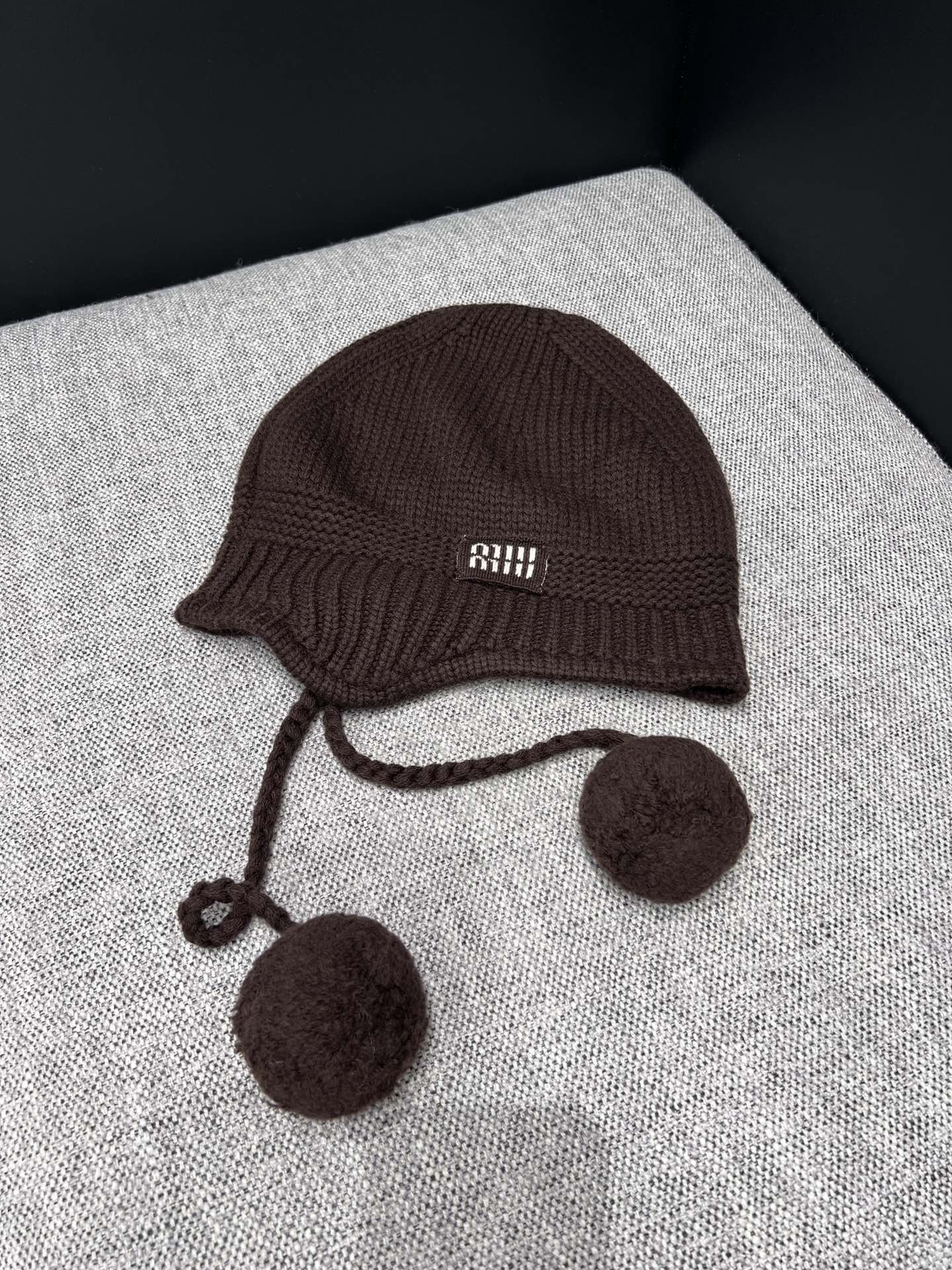 NO:517858,Support replacement Miumi* 25Fw autumn and winter new style, ear protection ball cashmere knit hat | Exclusive yb development!  High-end production!  Selected high-quality cashmere blend fabric, the knitted texture is delicate and dense, the touch is soft and skin-friendly, the classic ear-protecting style effectively resists the cold wind, protects both ears from freezing, the plush balls on both sides are playful and cute, injecting sweet elements into the overall shape; the hat body brand logo is low-key and recognizable, and the details show the identity of the luxury brand, and the sweet and cool style is instantly full. Spot sale one-size (F) real-time details pictures, miumiu, hats, alexander wang19860909支持换款 Miumi* 25Fw秋冬新款 护耳毛球羊绒针织帽丨独家yb开发！高版出品！精选高品质羊绒混纺面料,针织纹理细腻密实,触感柔软亲肤,经典护耳版型有效抵御寒风,呵护双耳不受冻,两侧的毛绒球俏皮可爱,为整体造型注入甜美元素；帽身品牌标识低调又具辨识度,细节处彰显奢牌身份,甜酷风格瞬间拉满.现货发售均码（F)实拍细节图,,miumiu,hats,alexander wang,Women's clothing