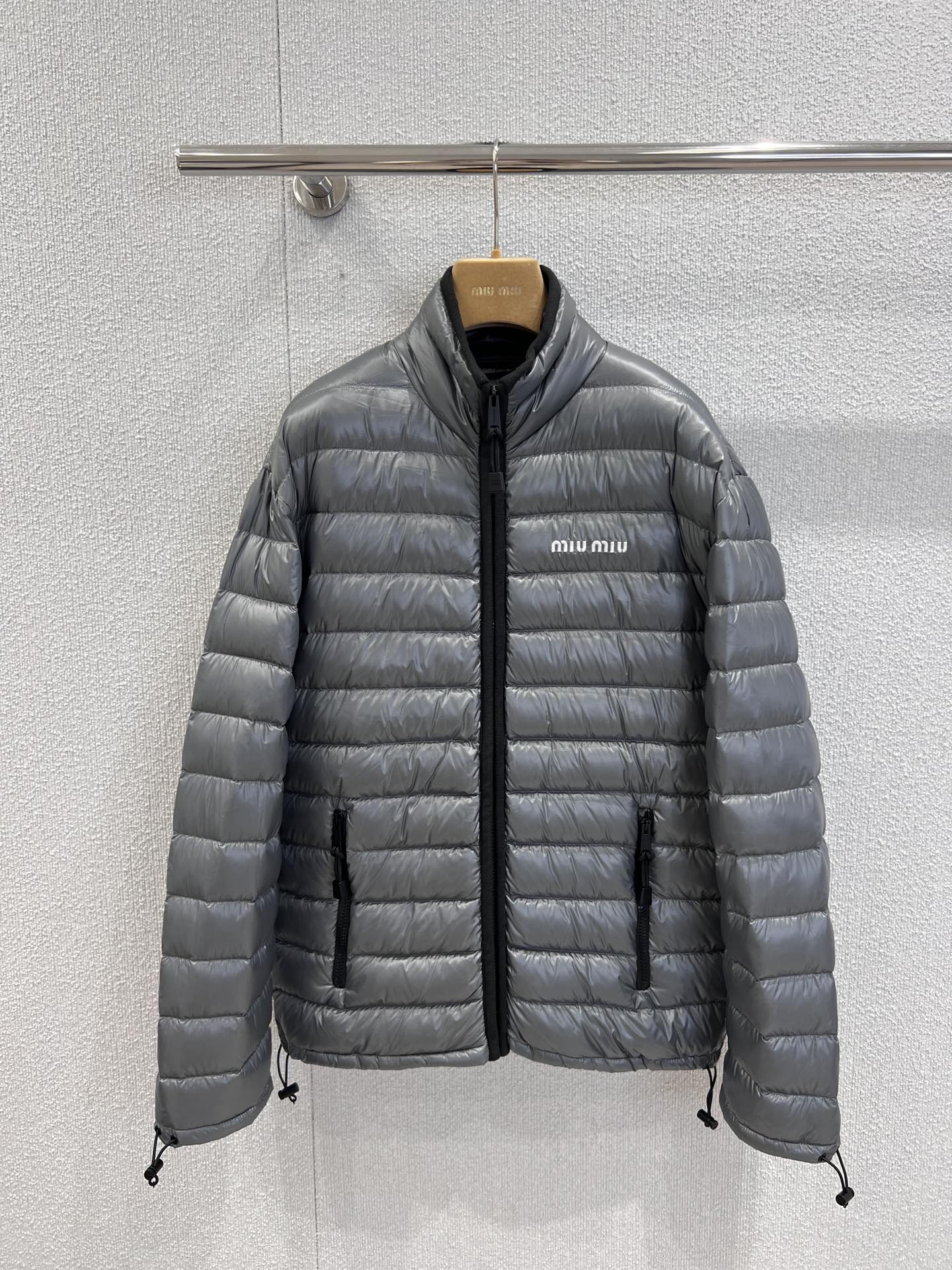 NO:536700,With dust bag Miumi* 25Fw autumn and winter new style logo embroidered down jacket jacket | Exclusive yb development!  High-end production!  The silver-gray matte fabric has a high-end texture, the classic quilting process makes the filling more even, the warmth is full but there is no bloated feeling. The eye-catching letter embroidered logo on the chest is a high-profile declaration of brand identity; the stand-up collar design is neat and the details of the black zipper and drawstring add a cool layer. The silhouette of the same style of men and women embraces all kinds of figures, and there is no pressure to wear the inner layer. The real details of S/M/L are on sale in stock, miumiu, jackets & coats, down jacket, alexander wang19860909配防尘袋 Miumi* 25Fw秋冬新款 徽标刺绣羽绒服外套丨独家yb开发！高版出品！银灰色哑光面料自带高级质感,经典绗缝工艺让充绒更均匀,保暖性拉满却毫无臃肿感.胸口醒目的字母刺绣徽标,是品牌身份的高调宣言；立领设计利落精神,黑色拉链与抽绳细节增添酷感层次,男女同款的廓形包容各种身材,叠穿内搭也毫无压力.现货发售S/M/L实拍细节图,,miumiu,jackets & coats,down jacket,alexander wang,Women's clothing