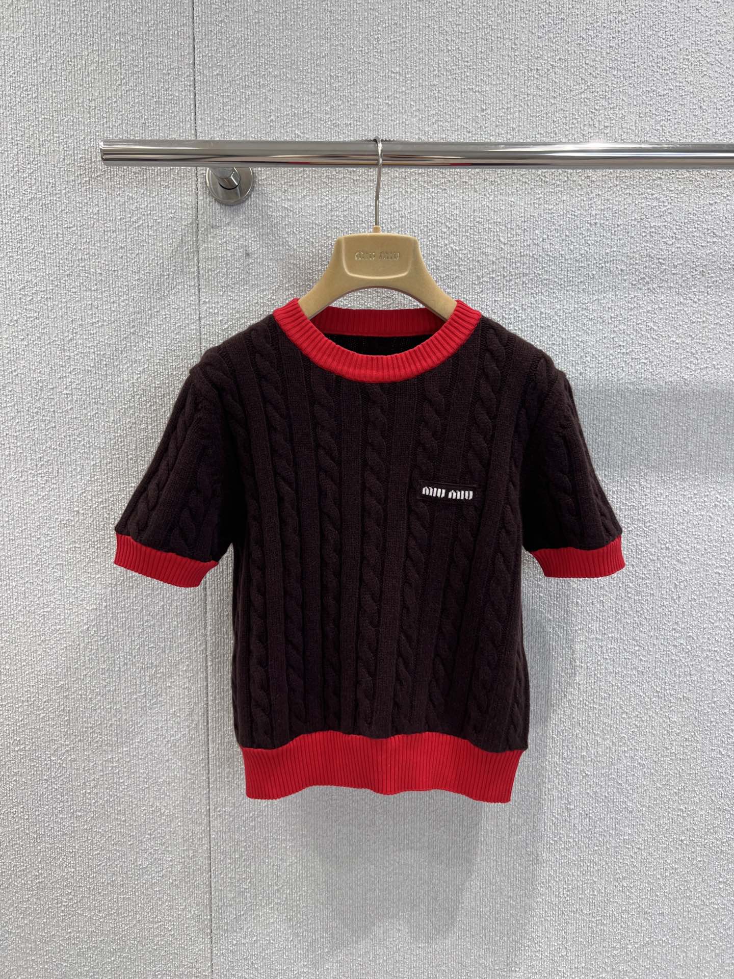 NO:546212,Support replacement Miumi* 25Fw early autumn new style logo slim twisted round neck wool short-sleeved sweater丨Exclusive yb development!  High-end production!  Selected high-quality wool fabrics, and the twist knitting technology gives the body a full three-dimensional texture, which not only retains the warmth and softness of wool, but also because the short-sleeved style is suitable for the early autumn climate, the skin is the gentle care of wool. Visually, it uses slim cut to outline the graceful figure, cleverly combining the French retro laziness with the girl's cuteness. The red and brown contrasting details are very recognizable. The round collar and the red edges of the cuffs are like a bright note jumping on the dark brown background. The exquisite logo embroidery on the chest shows the identity of the luxury brand in a low-key way, so that every detail hides the brand's ultimate pursuit of texture. S/M/L real-life details pictures are available in stock, miumiu, T-shirt, alexander wang19860909支持换款 Miumi* 25Fw早秋新款 徽标修身麻花圆领羊毛短袖针织衫丨独家yb开发！高版出品！甄选高品质羊毛面料,麻花针织工艺赋予衣身饱满立体的纹理感,既保留羊毛的温暖软糯,又因短袖版型适配早秋气候,贴肤穿着是羊毛的轻柔呵护,视觉上却凭借修身剪裁勾勒出曼妙身形,将法式复古的慵懒与少女的娇俏巧妙糅合.红棕撞色细节极具辨识度,圆领与袖口的红色包边,像一抹亮色音符跳跃在深棕底色上,胸前精致的徽标刺绣,低调彰显奢牌身份,让每一处细节都藏着品牌对质感的极致追求.现货发售S/M/L实拍细节图,,miumiu,T-shirt,alexander wang,Women's clothing