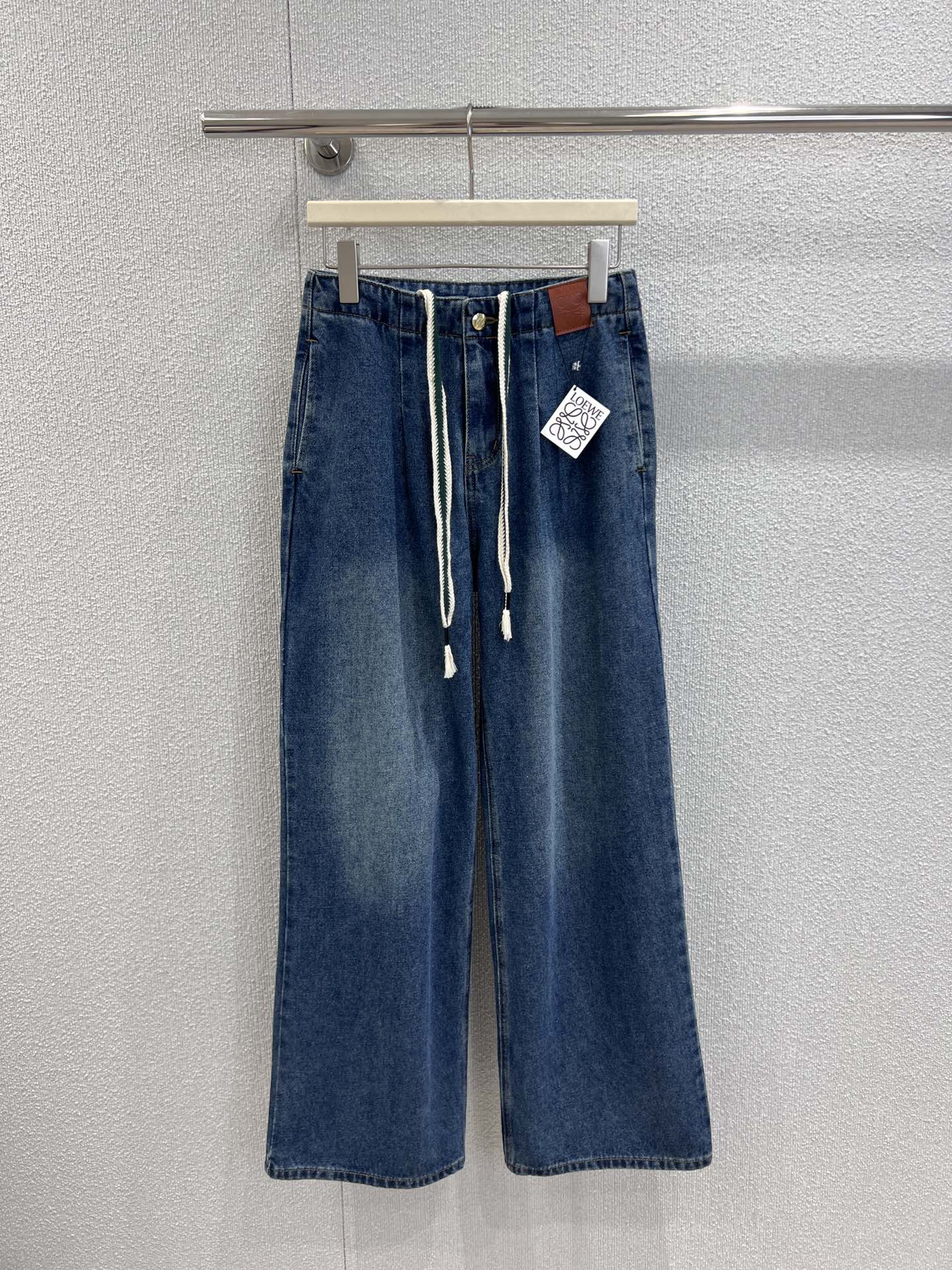 NO:549106,Support replacement Loew* 25Fw early autumn new style drawstring high waist wide-leg denim trousers | Exclusive high-end production!  A high-waist wide-leg silhouette is used, and the pants that naturally droop from the waist are decorated like a waterfall, which can fully express the casual and lazy French slack feeling when walking; a unique white knot drawstring on the waist is matched with the brand's iconic brown leather logo, which cleverly combines the casualness of the workwear style with the exquisiteness of the luxury brand, and the details of the tassel at the end of the drawstring add a bit of agility and fun. S/M/L real-life details pictures are available in stock, loewe, alexander wang19860909支持换款 Loew* 25Fw早秋新款 抽绳高腰阔腿牛仔长裤丨独家高版出品！采用高腰阔腿廓形,从腰头自然垂坠的裤型如瀑布般修饰腿线,行走间尽释随性慵懒的法式松弛感；腰间别出心裁的白色绳结抽绳,搭配品牌标志性的棕色皮革徽标,将工装风的率性与奢牌的精致感巧妙糅合,抽绳末端的流苏细节更添几分灵动趣味.现货发售S/M/L实拍细节图,,loewe,alexander wang,Women's clothing