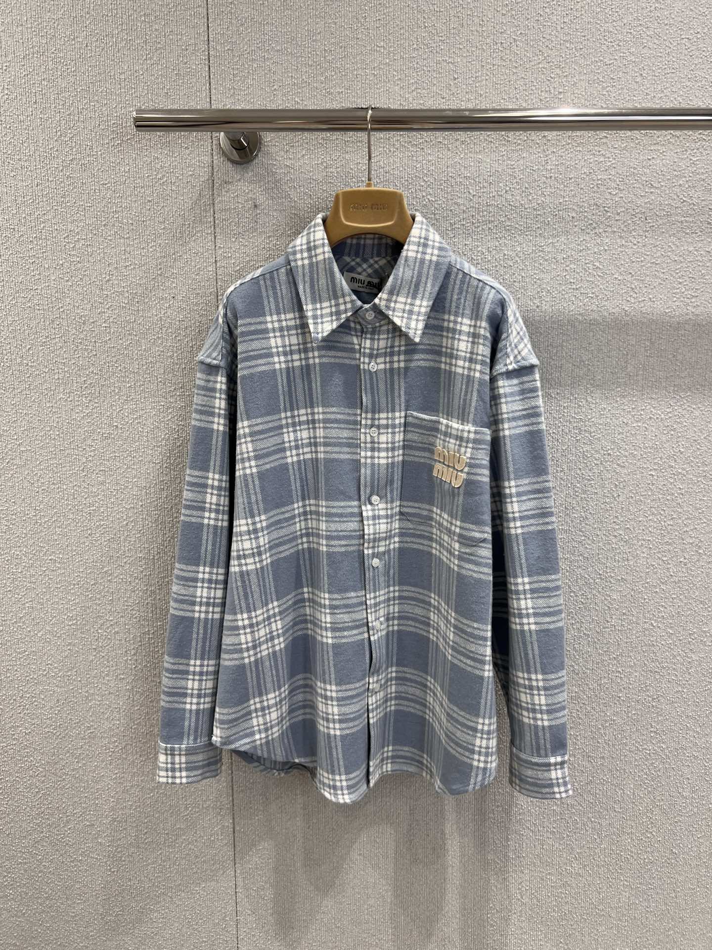 NO:569884,Support exchange Miumi* 25FW new autumn and winter pocket patch embroidered plaid long-sleeved shirt丨Exclusive high-end version!  Made of soft and skin-friendly plaid fabric, the loose fit is lazy and slim, and the classic lapels continue the neat texture of the shirt. The most eye-catching thing is the three-dimensional appliqué embroidered letter decoration on the chest pocket. On the retro background of the plaid, the brand's iconic playful vitality is injected, and every stitch reveals Miu style.  It's clever and interesting; the neat button closure and long-sleeved design allow it to be worn alone to create a sense of layering in autumn and winter, or layered as a style spice. Warm brown and light blue are available, ready for sale S/M/L real shot details,, miumiu, shirts, alexander  wang19860909支持换款 Miumi* 25FW 秋冬新款 口袋贴布绣格纹长袖衬衫丨独家高版出品！选用柔软亲肤的格纹面料,宽松版型慵懒又显瘦,经典翻领延续了衬衫的利落质感.最吸睛的当属胸前口袋的立体贴布绣字母装饰,在格纹的复古底色上,注入了品牌标志性的俏皮活力,每一针都透着Miu式的鬼马灵趣；利落的纽扣开合与长袖设计,让它在秋冬季节既能单穿打造层次感,又能叠穿充当风格调味剂.暖棕、浅蓝可选,现货发售S/M/L实拍细节图,,miumiu,shirts,alexander wang,Women's clothing