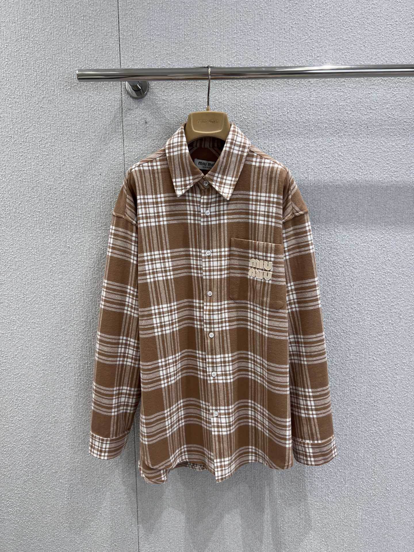 NO:569872,Support exchange Miumi* 25FW new autumn and winter pocket patch embroidered plaid long-sleeved shirt丨Exclusive high-end version!  Made of soft and skin-friendly plaid fabric, the loose fit is lazy and slim, and the classic lapels continue the neat texture of the shirt. The most eye-catching thing is the three-dimensional appliqué embroidered letter decoration on the chest pocket. On the retro background of the plaid, the brand's iconic playful vitality is injected, and every stitch reveals Miu style.  It's clever and interesting; the neat button closure and long-sleeved design allow it to be worn alone to create a sense of layering in autumn and winter, or layered as a style spice. Warm brown and light blue are available, ready for sale S/M/L real shot details,, miumiu, shirts, alexander  wang19860909支持换款 Miumi* 25FW 秋冬新款 口袋贴布绣格纹长袖衬衫丨独家高版出品！选用柔软亲肤的格纹面料,宽松版型慵懒又显瘦,经典翻领延续了衬衫的利落质感.最吸睛的当属胸前口袋的立体贴布绣字母装饰,在格纹的复古底色上,注入了品牌标志性的俏皮活力,每一针都透着Miu式的鬼马灵趣；利落的纽扣开合与长袖设计,让它在秋冬季节既能单穿打造层次感,又能叠穿充当风格调味剂.暖棕、浅蓝可选,现货发售S/M/L实拍细节图,,miumiu,shirts,alexander wang,Women's clothing