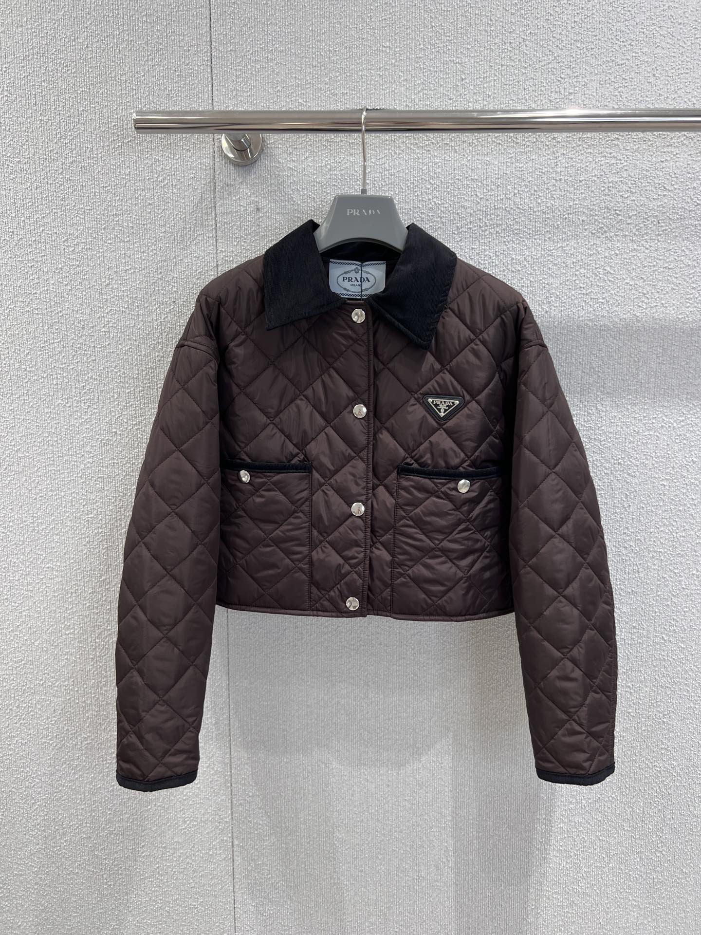 NO:569867,Support exchange Prad* 25FW new autumn and winter dark brown triangle cotton jacket丨Exclusive high-end version!  The cotton layer is filled with high-density windproof fabric, which has both warmth and lightness, and can handle the temperature difference between autumn and winter with ease. The iconic diamond quilting process not only strengthens the three-dimensional sense of the version, but also visually replicates the tough temperament of retro motorcycle style; corduroy lapels and metal snaps  The combination of details injects a sense of retro gentleman into the whole, and the triangular logo on the left chest is a low-key declaration of the brand's identity. Every design reveals the exquisite texture of Italian luxury brands. Real-shot details of S/M/L ready for sale, prada, jackets  & coats,alexander wang19860909支持换款 Prad* 25FW 秋冬新款 深棕三角标棉服外套丨独家高版出品！选用高密防风面料填充棉层,保暖性与轻便感兼具,应对秋冬温差游刃有余.标志性的菱格绗缝工艺不仅强化了版型的立体感,更在视觉上复刻了复古机车风的硬朗气质；灯芯绒翻领与金属按扣的细节组合,为整体注入了复古绅士感,而左胸处的三角徽标则是品牌身份的低调宣言,每一处设计都透着意式奢牌的精工质感.现货发售S/M/L实拍细节图,,prada,jackets & coats,alexander wang,Women's clothing