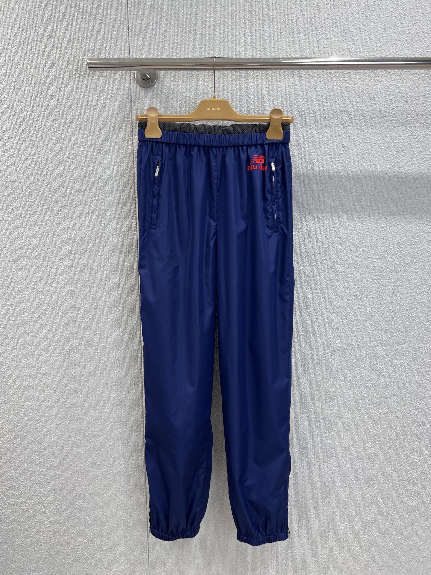 NO:576099,Support exchange Miumi*&New Bal*nce co-branded retro sports jogging trousers丨Exclusively developed by yb!  High quality production!  It is made of fine-textured nylon fabric, which is both light and stiff. The main color is navy blue with the brand's iconic red and white contrasting lines. The elastic waist design adapts to a variety of body shapes. The neat leg cut not only modifies the leg shape, but also makes the outfit more stylish. The dual-brand co-branded logo on the side of the pants is eye-catching. It not only retains New Bala*ce's classic sports genes, but also injects the sweet and cool retro luxury brand style of Miu.  Ready sale S/M/L real shot details,,miumiu,alexander wang19860909支持换款 Miumi*&New Bal*nce联名款 复古运动慢跑长裤丨独家yb开发！高版出品！采用质感细腻的尼龙面料,兼具轻便与挺括度,藏蓝色主调搭配品牌标志性红白撞色线条,松紧腰头设计适配多元身形,利落束脚剪裁修饰腿型的同时,让穿搭更具造型感.裤身侧边的双品牌联名徽标醒目吸睛,既保留 New Bala*ce 经典运动基因,又注入 Miu系甜酷复古的奢牌格调. 现货发售S/M/L实拍细节图,,miumiu,alexander wang,Women's clothing