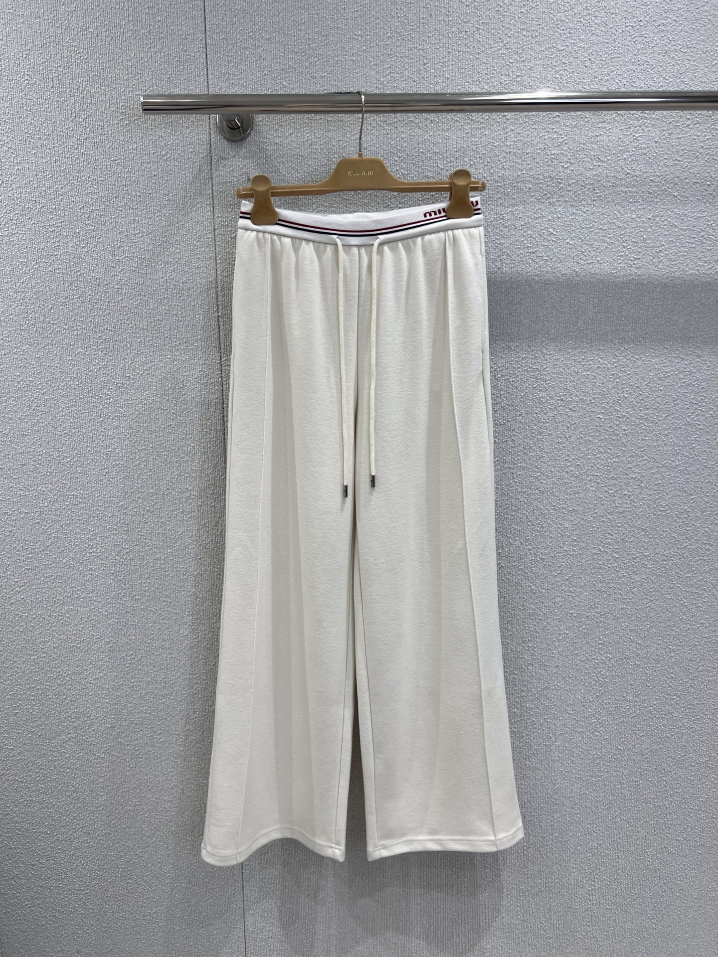 NO:576362,Support exchange Miumi* 25Fw new autumn and winter letter elastic waist drawstring casual wide-leg pants丨Exclusive high-end version!  Based on the lazy wide-leg silhouette, the drapey fabric sways gently with the steps, hiding the body and making it look slimmer while also adding a casual tone. The iconic lettered elastic waistband is the eye-catching highlight, and the red and white striped trim collides with the brand logo, instantly making you look  Awakening the brand recognition, locking the sense of luxury in the details; with metal drawstring, you can adjust the waistline casually, and add a bit of coolness. Ready-made S/M/L real shot details,, miumiu, alexander  wang19860909支持换款 Miumi* 25Fw秋冬新款 字母橡筋腰头抽绳休闲阔腿裤丨独家高版出品！以慵懒阔腿版型为基底,垂坠感十足的面料随着步伐轻轻摇曳,藏肉显瘦的同时,更将随性腔调拉满.标志性字母橡筋腰头是吸睛亮点,红白条饰边碰撞品牌Logo,瞬间唤醒品牌辨识度,把高级感锁在细节里；搭配金属抽绳,既能随性调节腰围,又添了几分率性酷感.现货发售S/M/L实拍细节图,,miumiu,alexander wang,Women's clothing