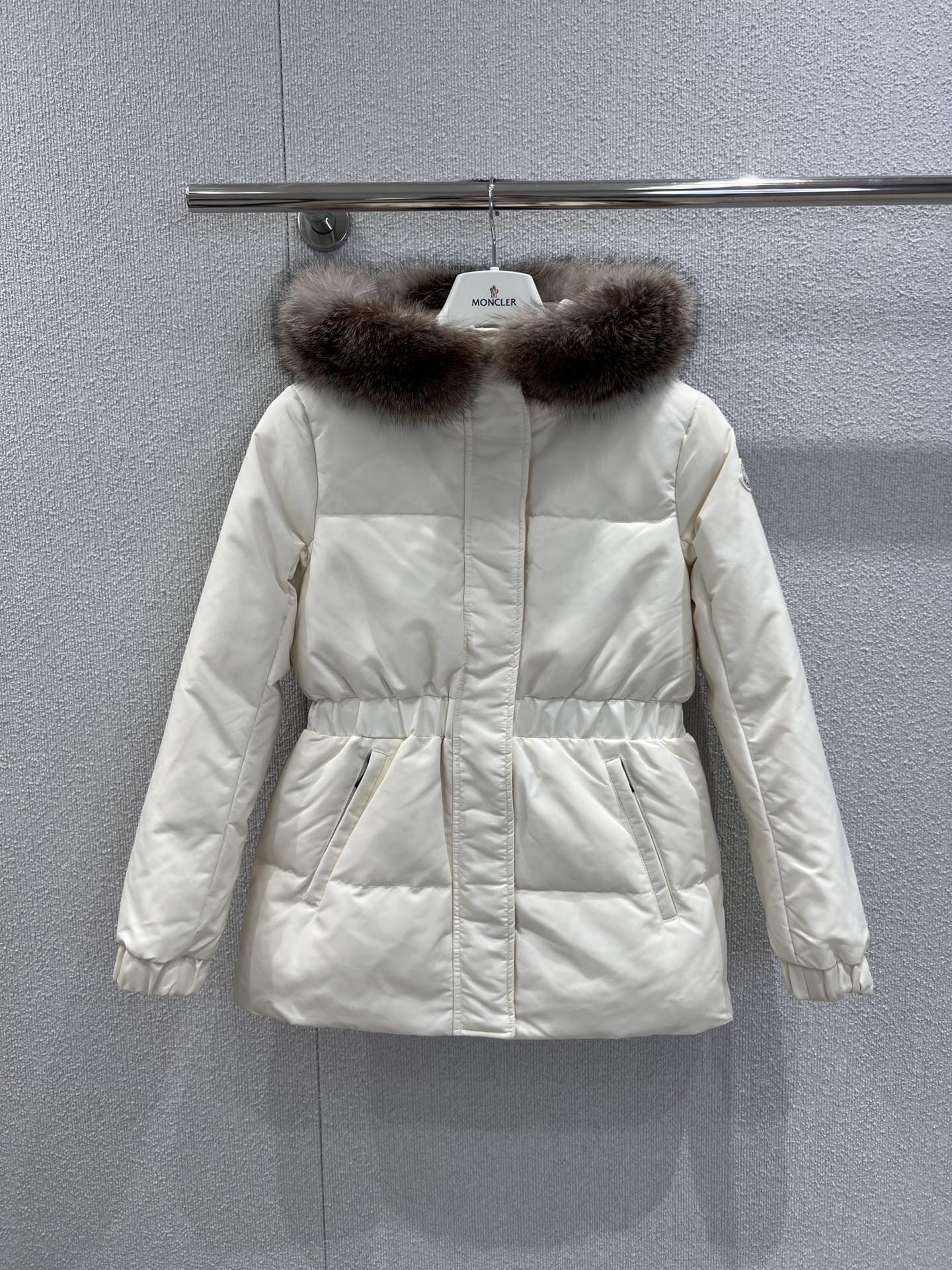 NO:578411,Comes with dust bag Moncl*r 25Fw new autumn and winter real fur collar hooded waist goose down down jacket丨Exclusive high-end version!  95 new national standard goose down filling!  The soft milky white color has a gentle atmosphere. The body is made of light and wind-resistant glossy fabric, and the hood is embellished with a rich fox fur collar. The fluffy texture not only enhances the sense of winter luxury, but also effectively resists the cold wind. The waist is designed with a drawstring, which can be adjusted freely, weakening the bloated feeling of the down jacket, easily outlining the waistline, and taking into account both comfort and slimming effects. Ready-made S/M/L real shot details, jackets &  coats,down jacket,hats,alexander wang19860909配防尘袋 Moncl*r 25Fw秋冬新款 真毛领连帽收腰鹅绒羽绒服外套丨独家高版出品！95新国标鹅绒填充！柔和的奶白色调自带温柔氛围,衣身采用轻盈且抗风的亮面面料,连帽处缀以丰盈的狐狸毛领,蓬松质感既提升了冬日奢华感,也能有效抵御寒风；腰部做抽绳收腰设计,可自由调节松紧,弱化了羽绒服的臃肿感,轻松勾勒出腰线,兼顾舒适与显瘦效果.现货发售S/M/L实拍细节图,,jackets & coats,down jacket,hats,alexander wang,Women's clothing