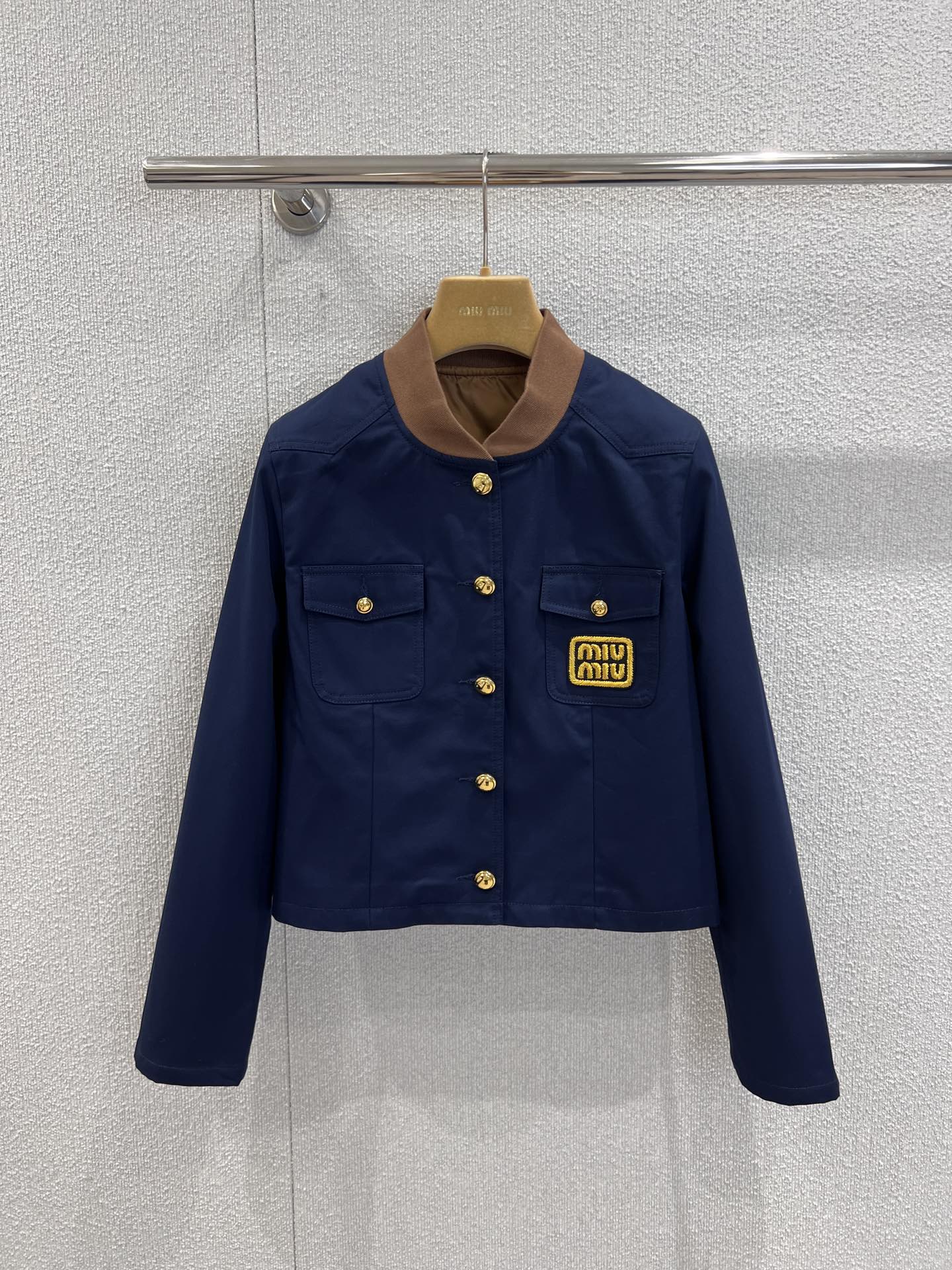 NO:605538,Support exchange Miu*iu 25Fw early autumn new style double pocket micro-label contrast collar jacket丨Exclusive high-end version!  The navy blue canvas fabric has a crisp texture, and the neat short version is accurately stuck to the waistline. The corduroy contrasting round neck + gold metal buckle, the retro texture is directly full; the double pockets + armband logo combine the casualness of the American campus with the sophistication of expensive brands; the cuff zipper design adds a sense of street relaxation, which is not exaggerated for daily wear, and is full of care in the details. Ready-made S/M/L real-shot detail photos, miumiu, jackets &  coats,jackets & coats,alexander wang19860909支持换款 Miu*iu 25Fw早秋新款 双口袋微标撞色领夹克外套丨独家高版出品！藏青帆布面料自带挺括质感,利落短款版型精准卡在腰线,灯芯绒撞色圆领+金色金属扣,复古质感直接拉满；双口袋+臂章徽标,把美式校园的随性和贵牌精致揉得恰到好处；袖口拉链设计添了份街头松弛感,日常穿不浮夸,细节里全是小心机.现货发售S/M/L实拍细节图,,miumiu,jackets & coats,jackets & coats,alexander wang,Women's clothing