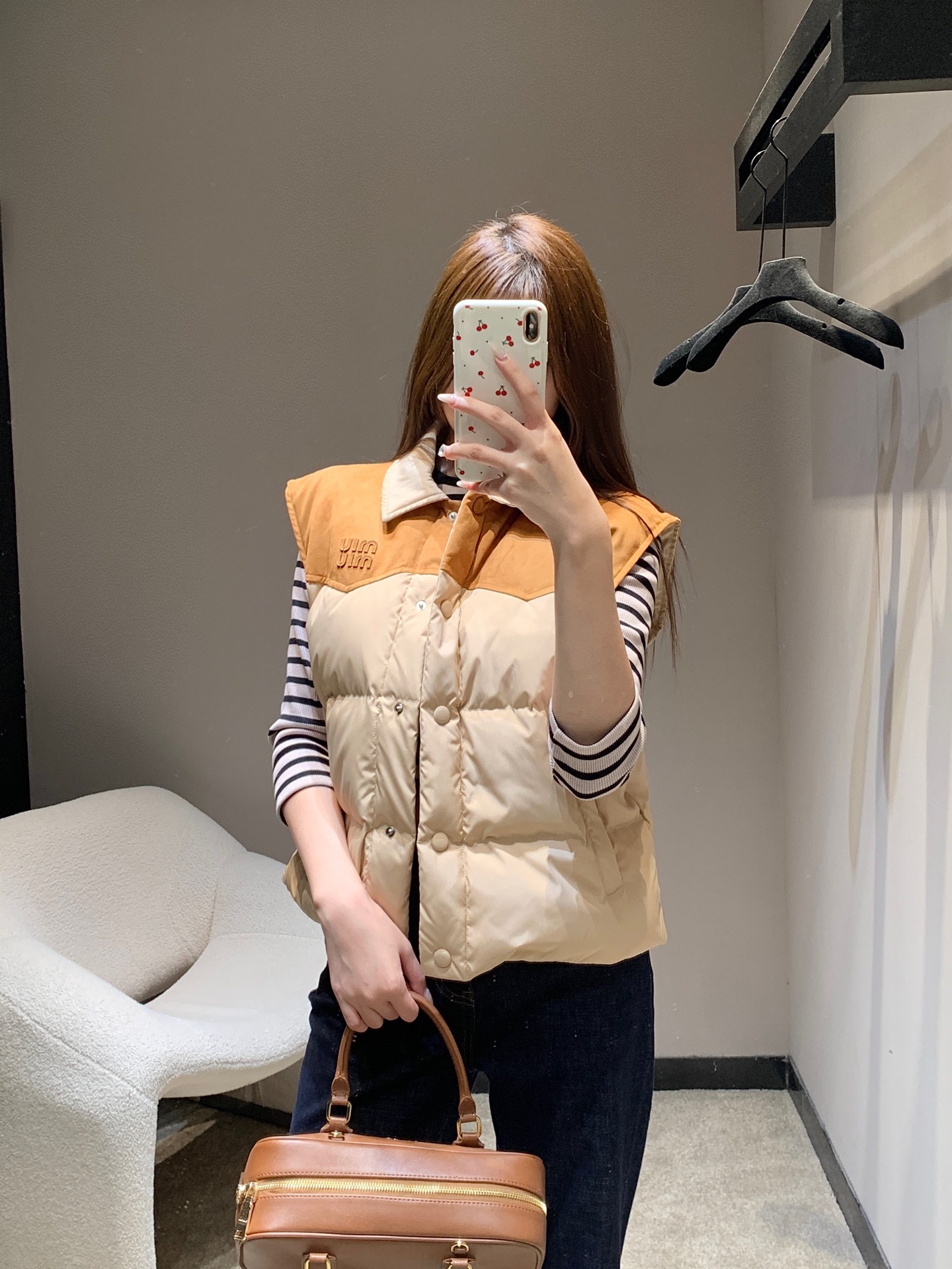 NO:607596,MiuM*u 25FW new autumn and winter style leather logo lapel stitching contrasting color down vest丨Exclusive high-end version!  Designed with leather splicing + letter logo as the core, the collar/shoulder area is made of caramel brown suede-like leather, which collides with the main milk tea apricot nylon fabric, and comes with a retro lazy filter; 90 white duck down filling, high fluffiness but no weight-bearing feeling  , taking into account the cold weather in autumn and winter and the flexibility of daily wear. The lapel version is suitable for layering, the single-row button opening and closing is easy to put on and take off, and the quilted velvet filling technology keeps you warm without looking bulky; ready for sale S/M/L,,miumiu,down  jacket,chamois leather,alexander wang19860909MiuM*u 25FW秋冬新款 皮革徽标翻领拼接撞色羽绒马甲丨独家高版出品！以皮革拼接+字母徽标为核心设计,领口/肩背区域采用焦糖棕麂皮质感皮革,与主体奶茶杏尼龙面料碰撞,自带复古慵懒滤镜；90白鸭绒填充,蓬松度高却无负重感,兼顾秋冬御寒与日常穿搭的灵动感.翻领版型适配叠穿,单排纽扣开合方便穿脱,绗缝充绒工艺既保暖又不显臃肿；现货发售S/M/L,,miumiu,down jacket,chamois leather,alexander wang,Women's clothing