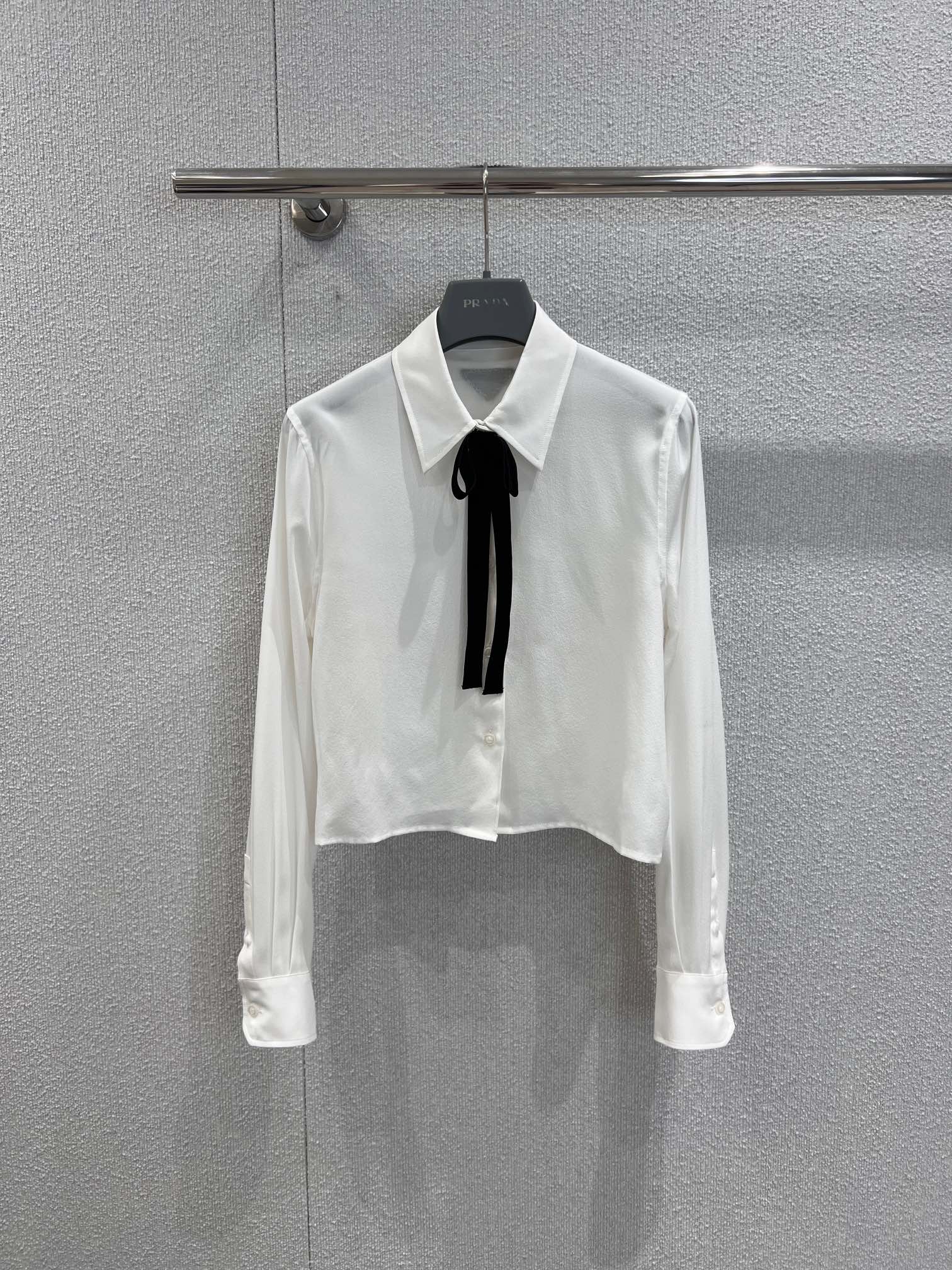 NO:622858,Supports exchange Prad* 25Fw new autumn and winter white collared mulberry silk shirt丨exclusively developed by yb!  High quality production!  The soft light of mulberry silk, with its own cooling filter, is drapey and light. The black velvet tie at the neckline is the finishing touch of retro style. The matte suede surface and the luster of real silk create a moody texture that is low-key but catchy. The short cut falls just above the waistline, neat and not procrastinating; the nobility is hidden in every inch of detail. Ready-made S/M/L real shot details, prada, shirts, real silk, alexander wang19860909支持换款 Prad* 25Fw秋冬新款 白色系带领桑蚕丝衬衫丨独家yb开发！高版出品！桑蚕丝的柔光感,自带清冷滤镜,垂坠又轻盈,领口的黑色丝绒领结,是点睛的复古腔调,哑光绒面和真丝的光泽形成质感情绪差,低调却抓人.短款剪裁刚好落在腰线以上,利落不拖沓；把贵气藏在每一寸细节里.现货发售S/M/L实拍细节图,,prada,shirts,real silk,alexander wang,Women's clothing
