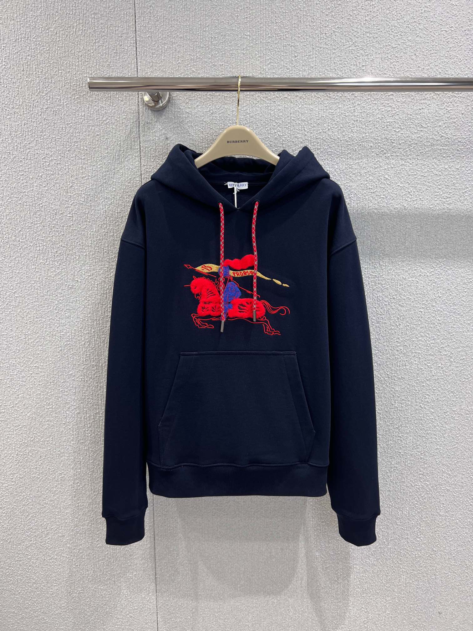 NO:664224,Support exchange Burb*rry 26ss New Year of the Horse limited new equestrian rider hooded sweatshirt丨Exclusively developed by yb!  High quality production!  The same style for men and women. The basic navy blue color has a sense of luxury. The knight logo embroidered in red and gold becomes the visual focus. The loose off-shoulder version can be sweet or cool, making it easy to capture the fashionable atmosphere of early spring. This limited-edition sweatshirt is not only a commemorative model for the zodiac, but also a universal and versatile king for early spring wear. Ready-made S/M/L real shot details, burberry, hoodie, sweatshirts, hats,  19860909支持换款 Burb*rry 26ss马年限定新款 马术骑士连帽卫衣丨独家yb开发！高版出品！男女同款,海军蓝的基础色调自带高级感,红金刺绣的骑士徽标成为视觉焦点,宽松落肩版型可甜可酷,轻松拿捏早春时尚氛围感.这件限定款卫衣不仅是生肖纪念款,更是早春穿搭的万能百搭王.现货发售S/M/L实拍细节图,,burberry,hoodie,sweatshirts,hats, ,Women's clothing