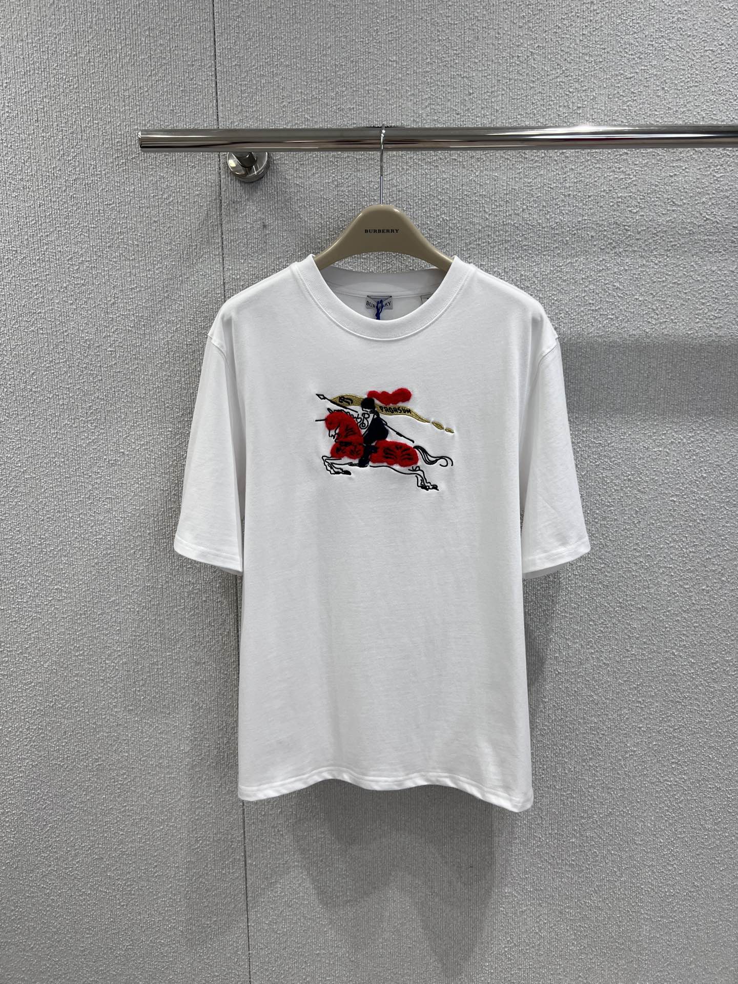 NO:665522,Support exchange Burber*y 26SS New Year limited equestrian knight logo round neck short-sleeved T-shirt丨Exclusively developed by yb!  High quality production!  The classic round neck cut is matched with a loose silhouette, and soft cotton fabrics are selected to create a comfortable wearing feeling. The embroidered equestrian knight logo on the chest is integrated into the New Year's red/pure white two-color design. The logo details are presented with three-dimensional embroidery. The red tone of the New Year's limited edition adds to the festive atmosphere. The simple version is suitable for various daily wear scenes. It is a fusion of light luxury leisure and festive rituals. Ready-made S/M/L real shot details, burberry, T-shirt, tees, t-shirt, alexander  wang19860909支持换款 Burber*y 26SS新年限定马术骑士徽标圆领短袖T恤丨独家yb开发！高版出品！以经典圆领剪裁搭配宽松廓形,甄选柔软棉质面料打造舒适穿着感.胸前刺绣马术骑士徽标融入新年红/纯净白双色设计,徽标细节采用立体绣艺呈现,新年限定款的红色调更添节日氛围,简约版型适配日常多种穿搭场景,是轻奢休闲与节日仪式感的融合之作.现货发售S/M/L实拍细节图,,burberry,T-shirt,tees，t-shirt, ,Women's clothing