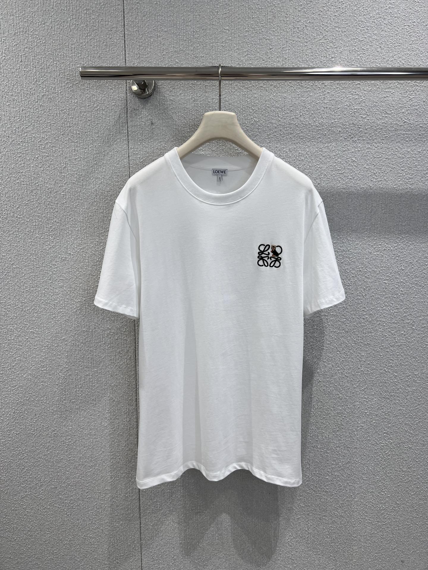 NO:665501,Supports exchange of styles Loew*  High quality production!  Joining hands with the well-known cat illustrator Louis Wain to create a joint series, using soft and breathable cotton fabrics, a classic round neck and a loose silhouette. The left chest is decorated with a delicate embroidery pattern that combines the Anagram logo and cat elements. The black and white/navy white two-color design is simple and ingenious. The loose version is suitable for men and women. It is a light luxury casual item with both artistic sense and practicality. Ready for sale S/M/L real shot details, Louis  vuitton,loewe,T-shirt,tees,t-shirt, 19860909支持换款 Loew* X Louis W*in26Ss猫咪系列新款 精美刺绣图案短袖简约T恤丨独家yb开发！高版出品！携手知名猫咪插画师Louis Wain打造联名系列,选用柔软透气的棉质面料,经典圆领搭配宽松廓形.左胸处饰有融合Anagram标识与猫咪元素的精美刺绣图案,黑白/藏青白双色设计简约又具巧思,宽松版型适配男女穿搭,是兼具艺术感与实穿性的轻奢休闲单品.现货发售S/M/L实拍细节图,,louis vuitton,loewe,T-shirt,tees，t-shirt, ,Women's clothing