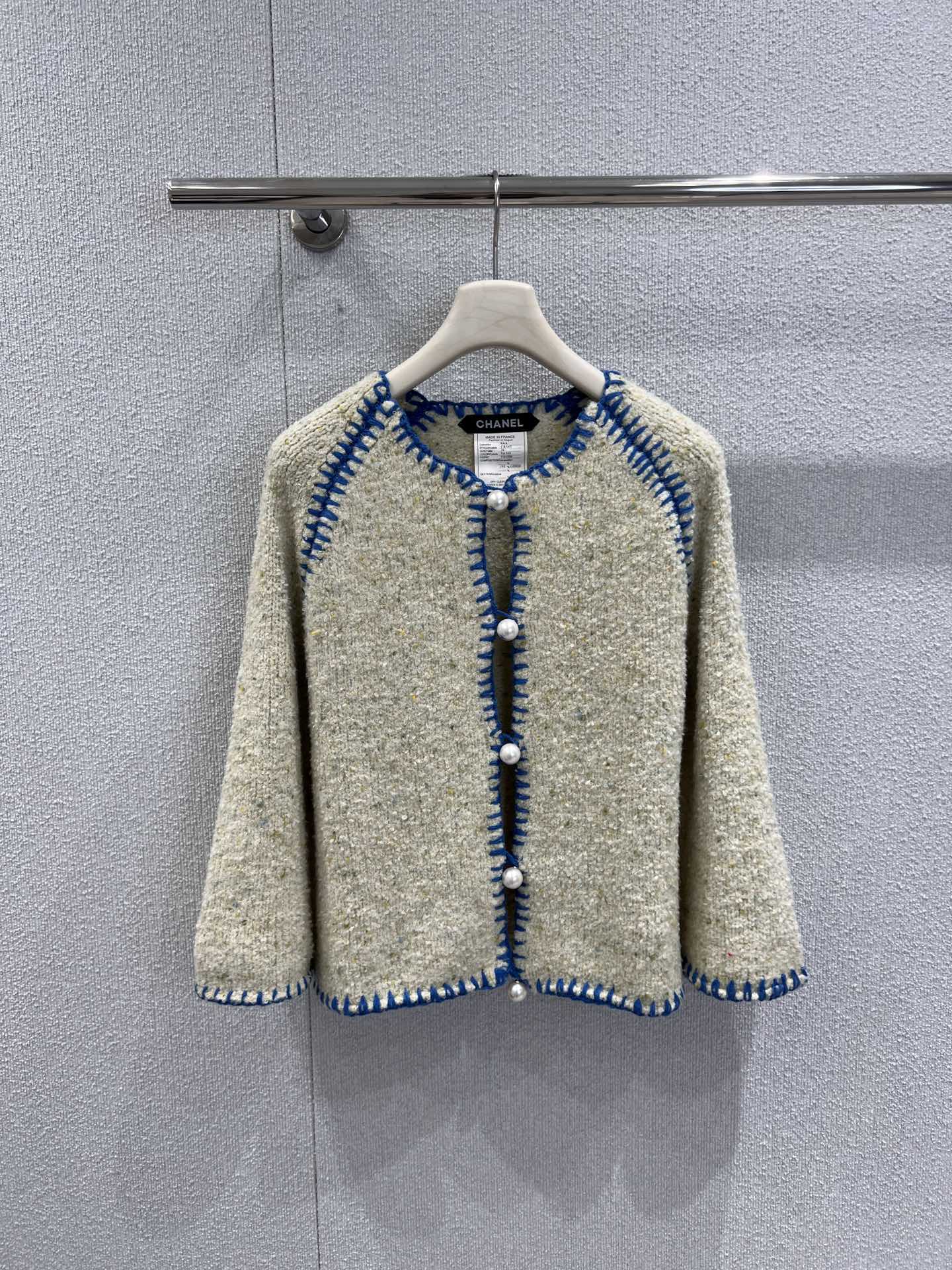 NO:686395,Supports exchange. Chane* 26C Advanced Handicraft Workshop Series New Color Block Yarn Single-breasted Knitted Cardigan丨Exclusive high-end version!  The custom-made blended floral yarn fabric is used, showing a unique texture with a creamy white background mixed with light gold dots. The classic collarless silhouette is suitable for various inner wears. The single row of pearl buttons are hand-polished by craftsmen, and the blue and white color matching are hand-stitched. The stitching is fine and three-dimensional, forming a contrasting color layer with the cream body, instantly filling the French retro atmosphere. Ready-made S/M/L real shot details,,chanel,19860909支持换款 Chane* 26C高级手工坊系列新款 拼色纱线单排扣针织开衫丨独家高版出品！选用定制混纺花纱面料,呈现出奶油白底色糅杂浅金杂点的独特肌理,经典的无领廓形适配各种内搭,单排珍珠纽扣由工匠手工打磨,蓝白拼色的手工锁边,针脚细密且立体,与奶油色衣身形成撞色层次,瞬间拉满法式复古氛围.现货发售S/M/L实拍细节图,,chanel,,Women's clothing