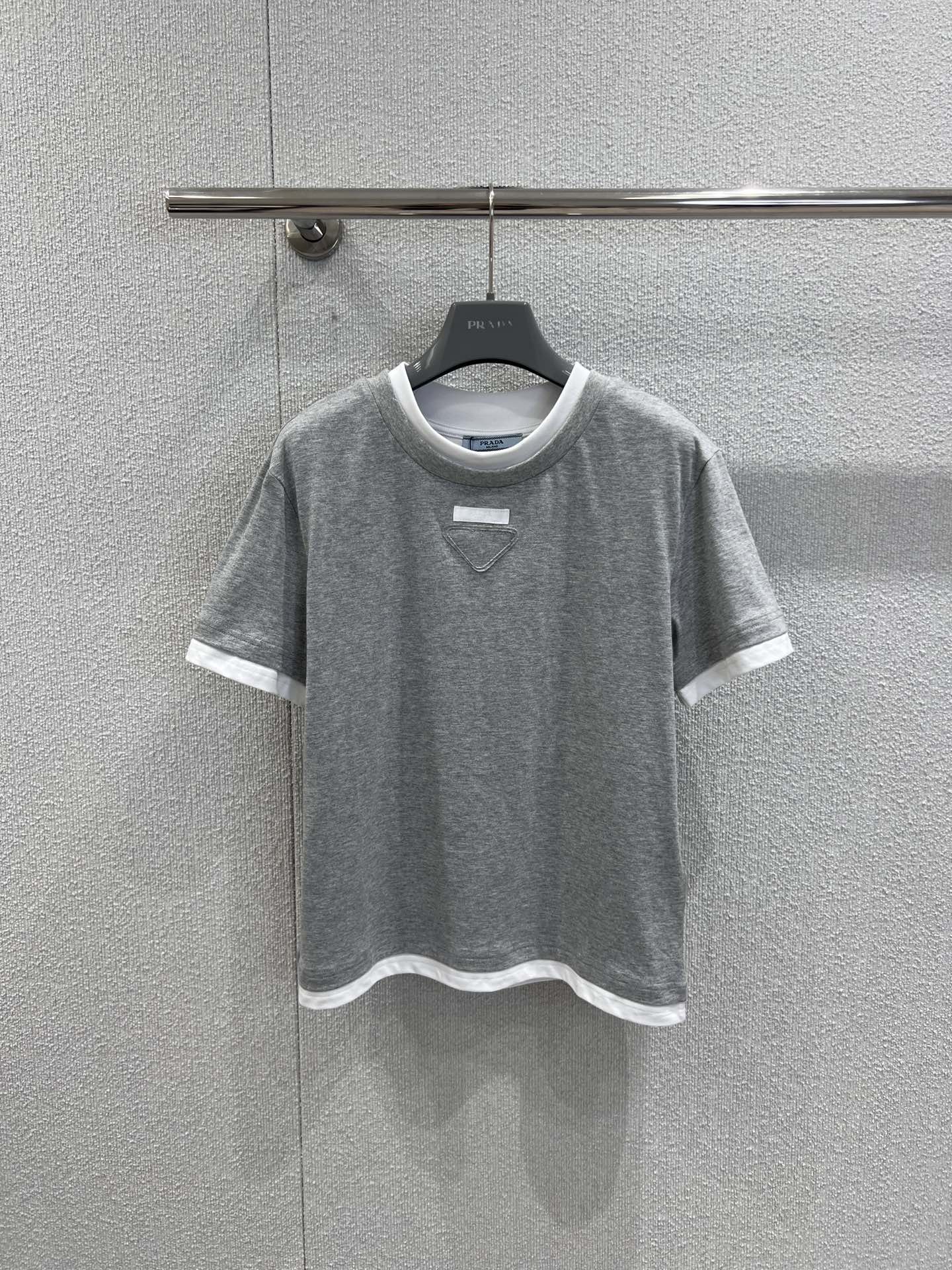 NO:685441,Support exchange Pra*a 26SS early spring new loose fake two-piece round neck short-sleeved T-shirt丨Exclusive high-end version!  Minimalist design combined with ingenious details. Two pieces of contrasting trim break the monotony of the basic model. The three-dimensional triangle logo hides brand recognition. Soft cotton fabric is selected to create a loose silhouette, which is skin-friendly, breathable and highly tolerant to the body shape. Available in navy blue and gray.  The classic colors are versatile and easy to wear. It is a basic luxury model that combines simple style and practicality for daily wear in early spring. Ready-made S/M/L real shot details, prada, T-shirt, tees, t-shirt,19860909支持换款 Pra*a 26SS早春新款 宽松假两件圆领短袖T恤丨独家高版出品！以极简设计糅合巧思细节.假两件撞色边饰打破基础款的单调,立体三角标识暗藏品牌辨识度,甄选柔软棉质面料打造宽松廓形,亲肤透气且对身形包容度极高.藏青与灰色两大经典色系百搭不挑人,是早春日常穿搭中兼具简约格调与实穿性的奢品基础款.现货发售S/M/L实拍细节图,,prada,T-shirt,tees，t-shirt,,Women's clothing