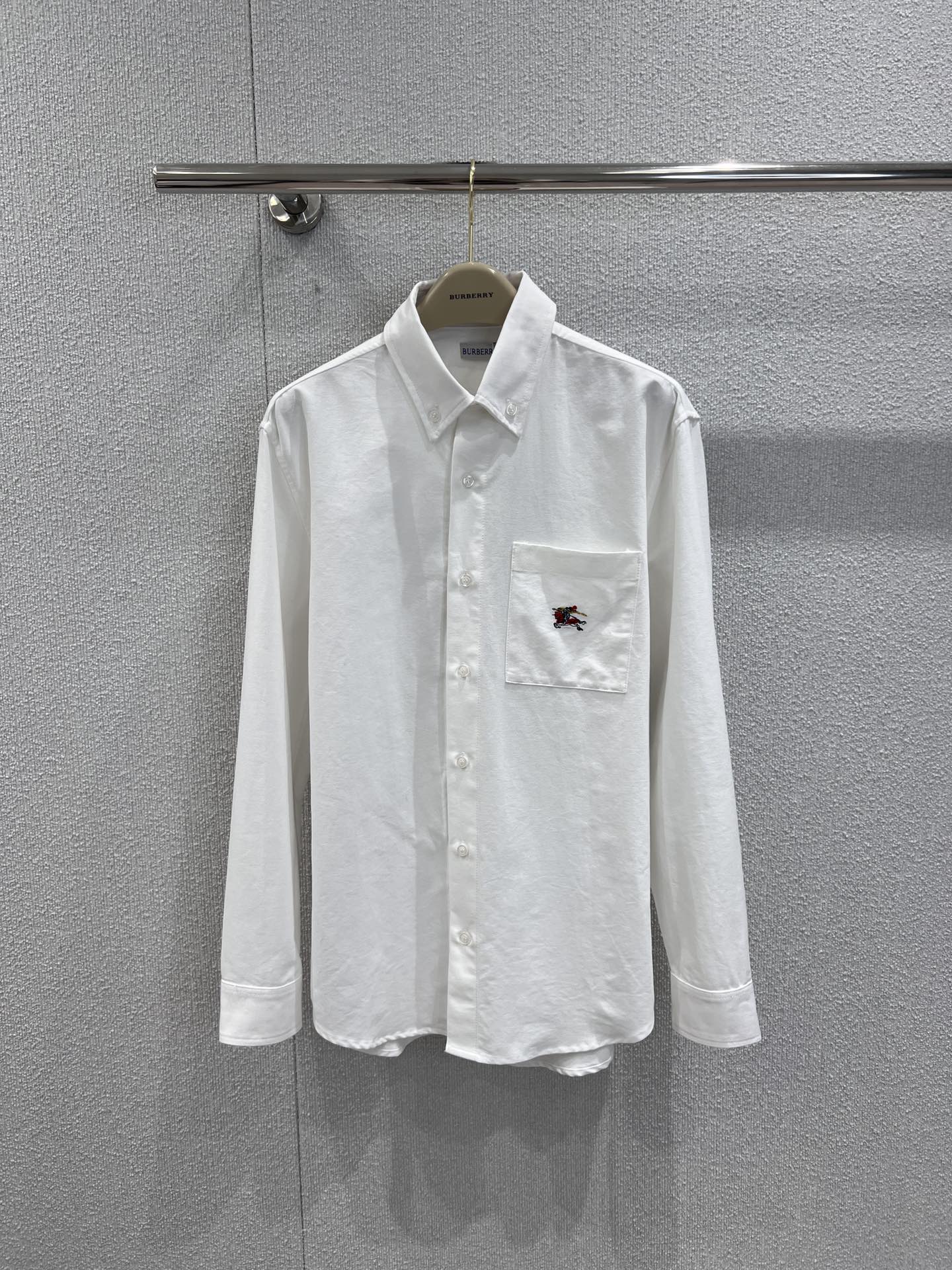 NO:686411,Supports exchange Burberr* 25Fw new autumn and winter loose version cotton Oxford long-sleeved shirt丨Exclusively developed by yb!  High quality production!  The fabric is selected from high-count combed Oxford cotton, which has been treated with a special washing process. It is soft to the touch and retains the unique crisp texture of Oxford cloth. The classic logo of the equestrian knight is embroidered on the chest pocket. The buttons are made of natural mother-of-pearl buttons, which have a warm luster and create a material collision with the pure white shirt. The placket of the shirt is neatly routed, and the buttons on the cuffs can be adjusted freely, which perfectly interprets the effortless fashion of the British gentleman. Real-shot details of S/M/L ready fo19860909支持换款 Burberr* 25Fw秋冬新款 宽松版棉质牛津长袖衬衫丨独家yb开发！高版出品！面料甄选高支精梳牛津棉,经特殊水洗工艺处理,触感柔软且保留了牛津布独有的挺括肌理,胸前口袋的马术骑士刺绣经典标识,纽扣选用天然贝母扣,光泽温润与纯白衬衫形成材质碰撞,衬衫的门襟走线工整,袖口的纽扣可自由调节,完美诠释英伦绅士的不费力时髦.现货发售S/M/L实拍细节图,,burberry,shirts,,Women's clothing