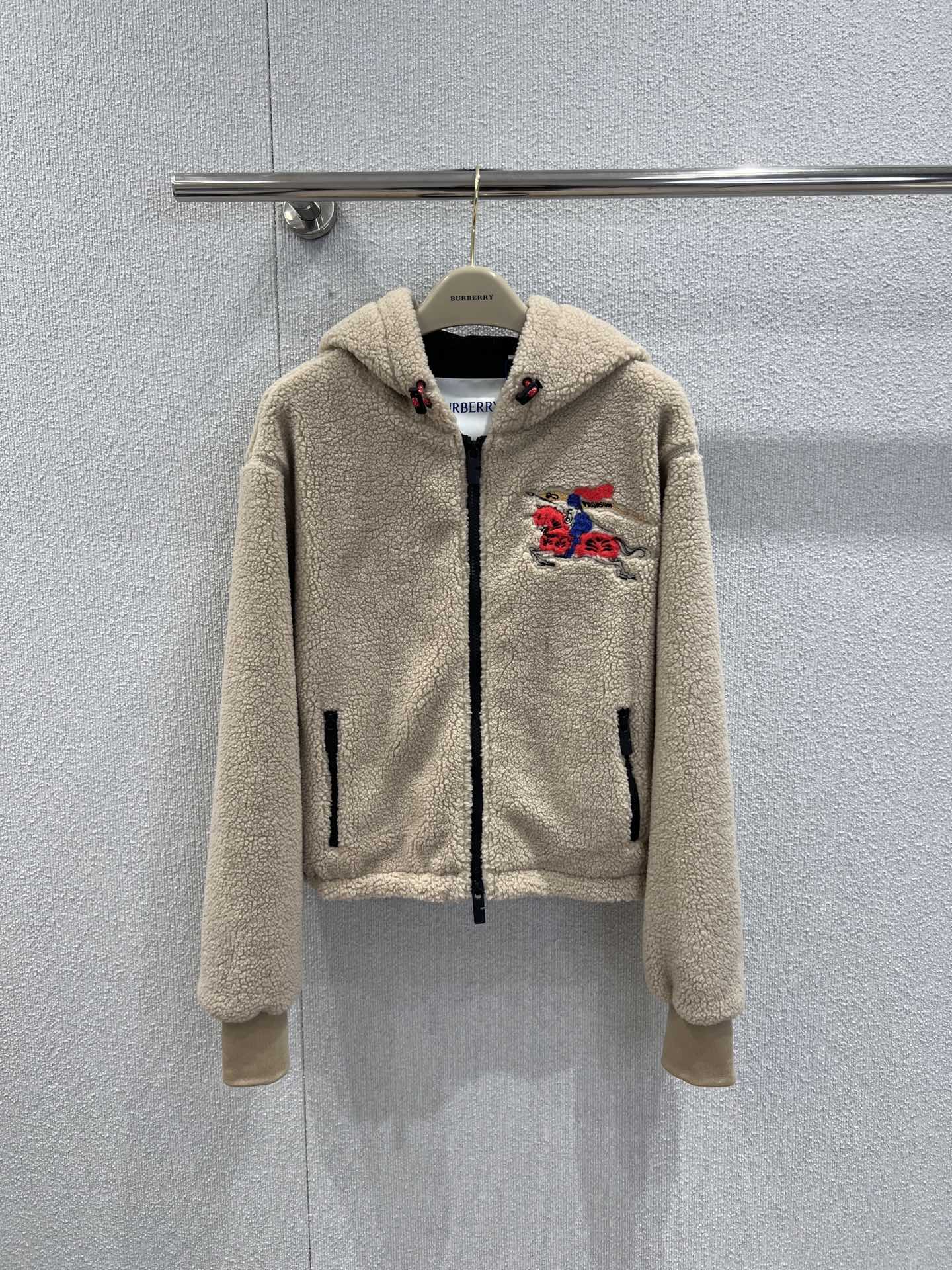 NO:695275,Support exchange Burb*rry 26Ss early spring new equestrian rider micro-label lamb wool Teddy jacket丨exclusively developed by yb!  Top quality production!  Made of high-quality lamb wool fabric, it feels as fluffy and soft as clouds, is skin-friendly and warm, and is very practical for windproof and cold protection in early spring. It is available in classic navy blue and off-white colors. The body is embellished with the brand's iconic equestrian knight embroidery logo, and the red thread embroidery outlines the brand recognition in a low-key manner, which is simple but without losing the sense of detail.  The neat stand-up collar (some models are hooded) is paired with a full zipper closure, and the loose oversize version is super tolerant for both men and women, making it easy to create a casual British casual accent. Ready-made S/M/L real shot details, burberry, versace, jackets  & coats,hats,19860909支持换款 Burb*rry 26Ss早春新款 马术骑士微标羊羔毛泰迪外套丨独家yb开发！顶级高版出品！采用高品质羊羔毛面料,触感如云朵般蓬松软糯,亲肤又保暖,早春防风御寒超实用.经典的藏青与米白双色可选,衣身点缀品牌标志性的马术骑士刺绣徽标,红彩线绣纹在低调中勾勒出品牌辨识度,简约却不失细节感.利落的立领（部分款为连帽）搭配全拉链开合,宽松的oversize版型对男女身形都超包容,轻松打造随性的英伦休闲腔调.现货发售S/M/L实拍细节图,,burberry,versace,jackets & coats,hats,,Women's clothing