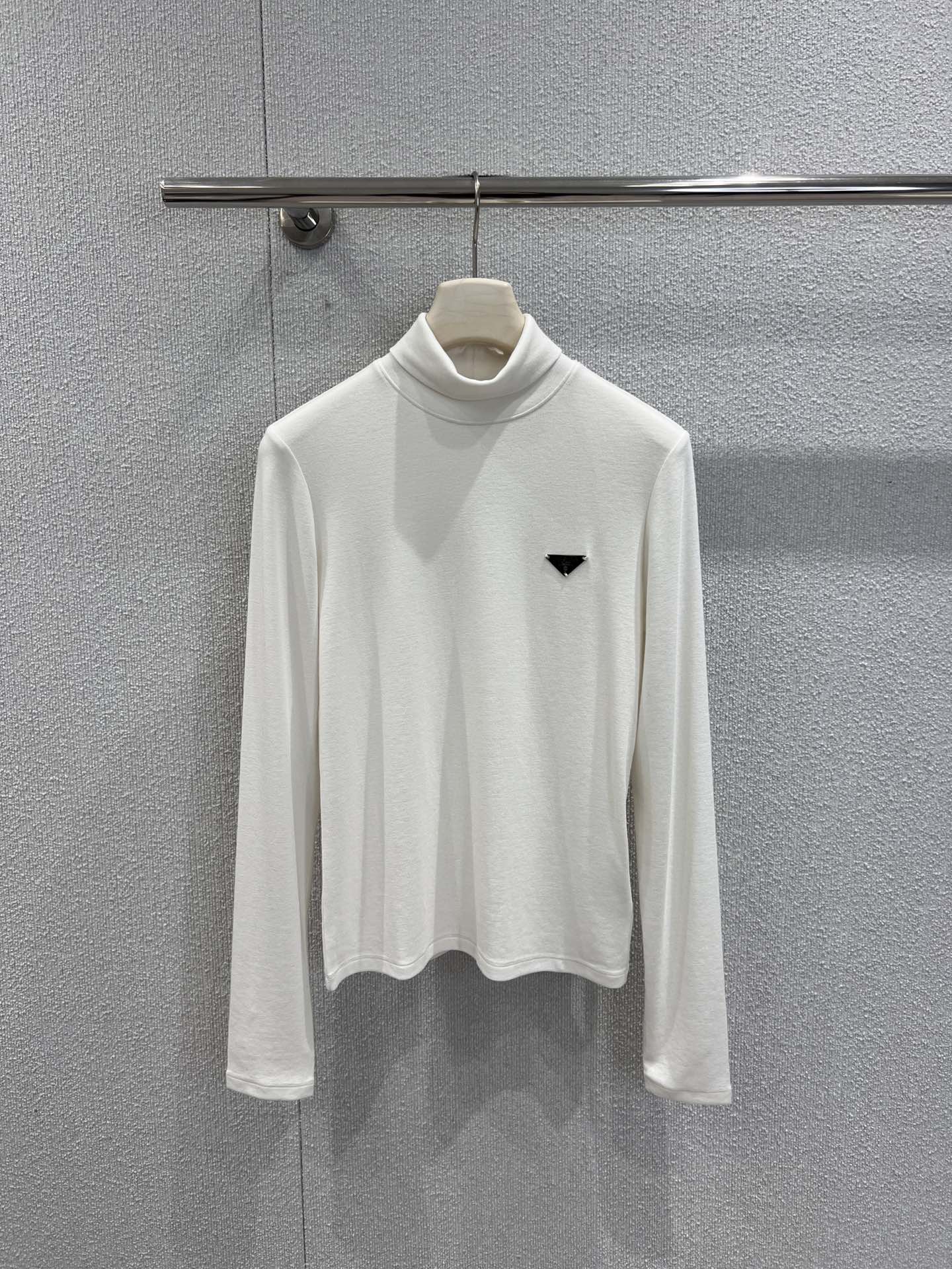NO:695286,Supports exchange Prad* 25FW new autumn and winter triangle high collar long-sleeved bottoming shirt | Exclusive high-end version!  Made of fine and soft fabrics, it feels smooth and comfortable against the body. The high-neck design is both warm and stylish, suitable for a variety of layering scenarios; the slim cut optimizes the body proportions, and the upper body is neat and clean. The triangle logo on the chest is embellished, revealing the brand gene in a low-key manner, making simplicity no longer simple. Black, white and coffee are available in three colors, which can be easily integrated into various styles. Ready-made S/M/L real shot details, prada,19860909支持换款 Prad* 25FW秋冬新款 三角标高领长袖打底衫丨独家高版出品！采用细腻柔软面料,触感顺滑,贴身舒适不束缚.高领设计兼具保暖与造型感,适合多种叠穿场景；修身剪裁优化身形比例,上身利落干净.胸前三角标点缀,在低调中流露品牌基因,让简约不再简单.黑白咖三色可选,轻松融入各类风格搭配.现货发售S/M/L实拍细节图,,prada,,Women's clothing