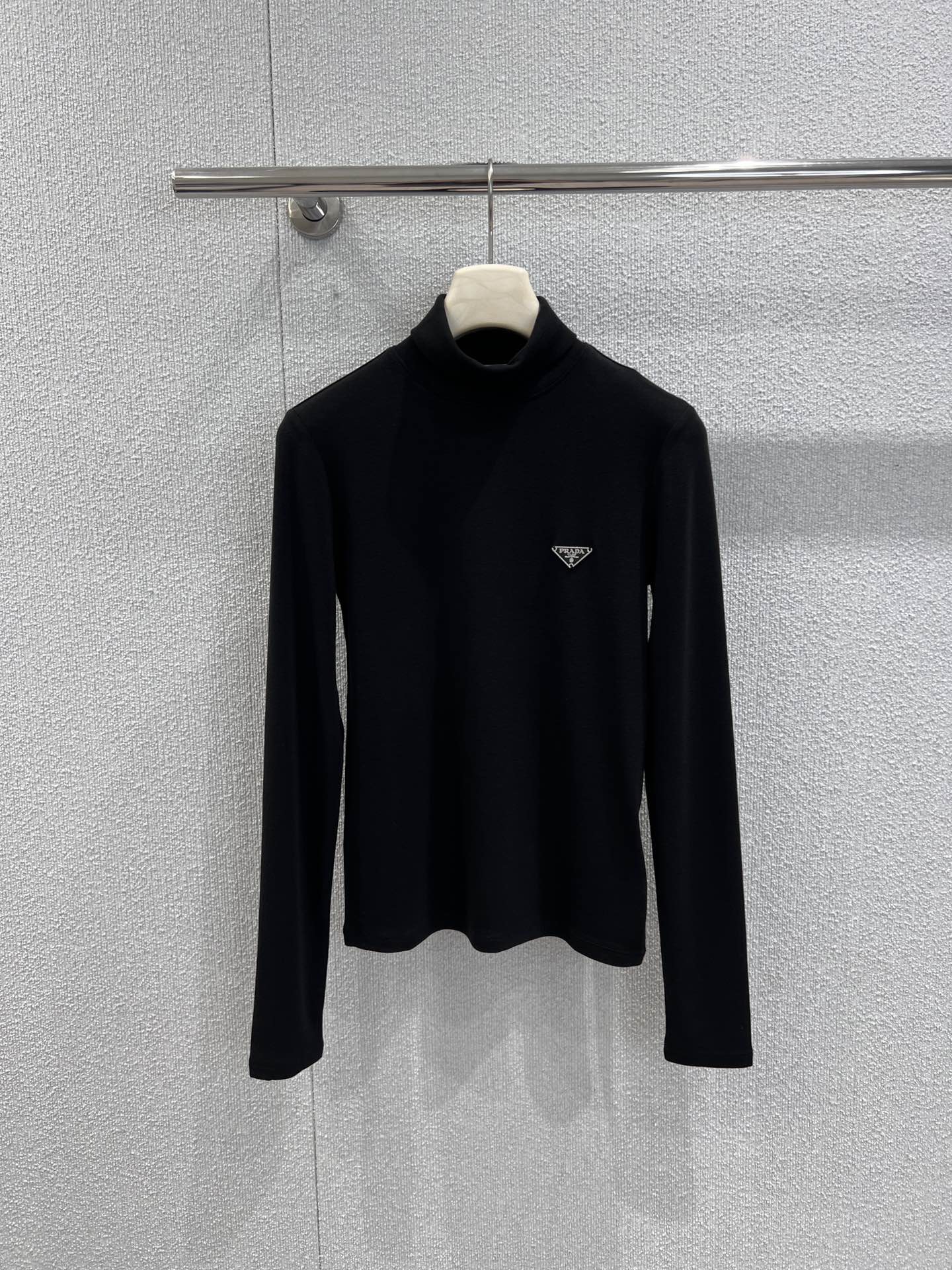 NO:695305,Supports exchange Prad* 25FW new autumn and winter triangle high collar long-sleeved bottoming shirt | Exclusive high-end version!  Made of fine and soft fabrics, it feels smooth and comfortable against the body. The high-neck design is both warm and stylish, suitable for a variety of layering scenarios; the slim cut optimizes the body proportions, and the upper body is neat and clean. The triangle logo on the chest is embellished, revealing the brand gene in a low-key manner, making simplicity no longer simple. Black, white and coffee are available in three colors, which can be easily integrated into various styles. Ready-made S/M/L real shot details, prada,19860909支持换款 Prad* 25FW秋冬新款 三角标高领长袖打底衫丨独家高版出品！采用细腻柔软面料,触感顺滑,贴身舒适不束缚.高领设计兼具保暖与造型感,适合多种叠穿场景；修身剪裁优化身形比例,上身利落干净.胸前三角标点缀,在低调中流露品牌基因,让简约不再简单.黑白咖三色可选,轻松融入各类风格搭配.现货发售S/M/L实拍细节图,,prada,,Women's clothing