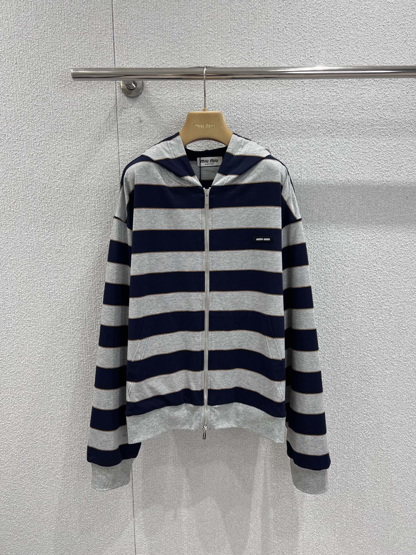 NO:697756,Support exchange Miumi* 26Ss early spring new style micro-label striped zipper hooded sweatshirt jacket丨Exclusively developed by yb!  Top quality production!  The classic stripes of navy blue and heather gray collide to outline a casual and sweet modern silhouette. The custom-made high-count cotton blended fabric is soft to the skin, with both airiness and stiffness. The loose shoulder cut is suitable for various body shapes, and can freely unlock a lazy and casual wearing posture. The mini logo embroidery on the side of the body is low-key.  The brand identity is engraved, and the delicate metal zipper extends along the striped texture, becoming the visual focus and making putting on and taking off more ritualistic. Ready-made S/M/L real shot details,,miumiu,hoodie,sweatshirts,jackets  & coats,hats,19860909支持换款 Miumi* 26Ss早春新款 微标条纹拉链连帽卫衣外套丨独家yb开发！顶级高版出品！以藏青与麻灰的经典条纹碰撞,勾勒出率性又甜美的摩登轮廓.定制高支棉混纺面料触肤柔软,兼具空气感与挺括度,宽松落肩剪裁适配多元身形,自在解锁慵懒随性的穿搭姿态.衣身侧边的迷你徽标刺绣低调镌刻品牌身份,细巧的金属拉链顺着条纹肌理延伸,成为视觉焦点的同时,也让穿脱更具仪式感.现货发售S/M/L实拍细节图,,miumiu,hoodie,sweatshirts,jackets & coats,hats,,Women's clothing