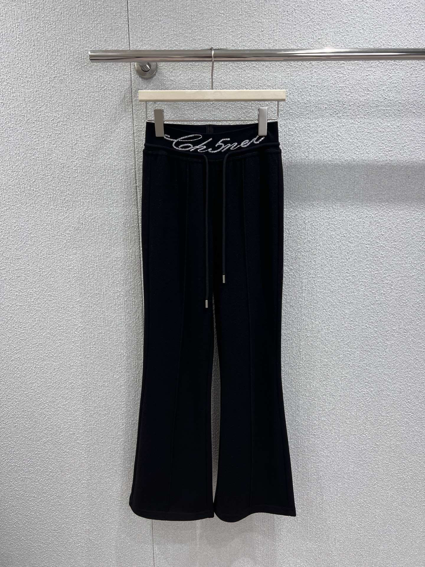 NO:697729,Supports exchange Cha*el 25Fw new autumn and winter style casual trousers with rhinestoned letter waistband丨Exclusive high-end version!  The classic black and white two-color interpretation of French elegance. The hot-drilling process of the brand letters on the waist is the finishing touch. The Swarovski rhinestones are inlaid and arranged by hand, reflecting the delicate and bright luster under the light, showing the exquisite craftsmanship of the haute couture workshop. The matte knitted wool fabric is selected and brushed to feel soft and warm, with both drape and shaping ability.  ; The high-waisted and slightly flared version cleverly raises the waistline, and the natural drape lines from the waist to the trouser legs modify the proportions of the legs. The loose trousers accommodate the shape of the legs and can be perfectly matched with short tops, sweaters and other items, injecting a lazy and high-end modern style into the autumn and winter looks. Ready-made S/M/L real shot details,,swarovski,19860909支持换款 Cha*el 25Fw秋冬新款 字母烫钻腰头休闲长裤丨独家高版出品！以经典黑白双色诠释法式奢雅,腰头处的品牌字母烫钻工艺堪称点睛之笔,施华洛世奇水钻经手工镶嵌排列,在光线下折射出细腻璀璨的光泽,尽显高定工坊的精湛匠艺.精选哑光针织羊毛面料,经磨毛处理后触感软糯温暖,兼具垂坠感与塑形力；高腰微喇版型巧妙拉高腰线,从腰腹到裤脚的自然垂坠线条修饰腿部比例,宽松裤管包容腿型的同时,又能与短上衣、针织衫等单品完美搭配,为秋冬造型注入慵懒又高级的摩登格调.现货发售S/M/L实拍细节图,,swarovski,,Women's clothing