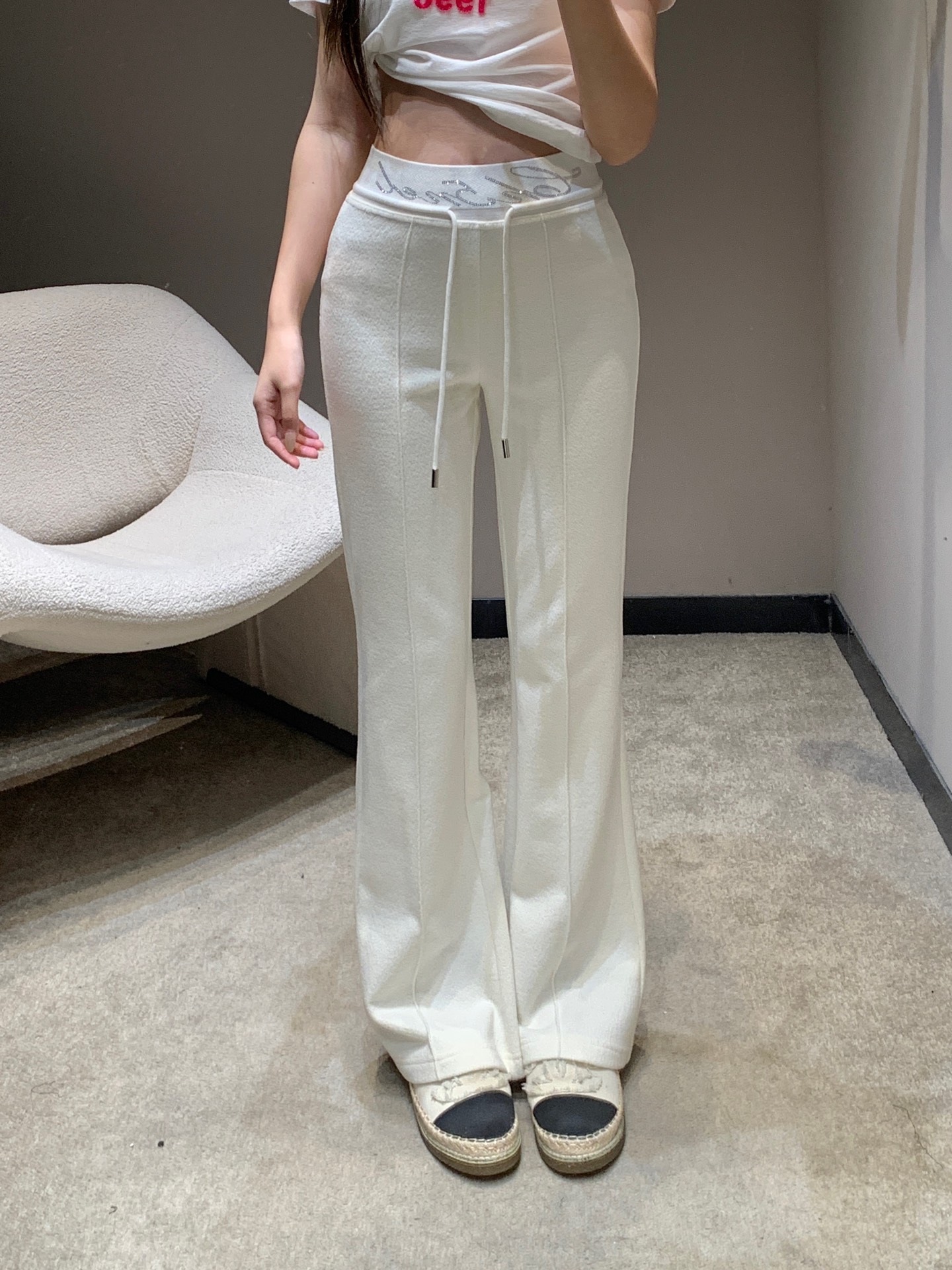 NO:697724,Cha*el 25Fw new autumn and winter style casual trousers with rhinestoned letter waistband | Exclusive high-end version!  The French elegance is interpreted in classic black and white colors. The hot-drilling process of the brand letters at the waist is the finishing touch. The Swarovski rhinestones are inlaid and arranged by hand, reflecting the delicate and bright luster under the light, showing the exquisite craftsmanship of the haute couture workshop. The matte knitted wool fabric is selected, and after brushing treatment, it feels soft and warm, with a drapey and elegant feel.  Shaping power; the high-waisted and slightly flared version cleverly raises the waistline, and the natural drape lines from the waist to the trouser legs modify the proportions of the legs. The loose trouser legs accommodate the leg shape and can be perfectly matched with short tops, sweaters and other items, injecting a lazy and high-end modern style into the autumn and winter looks. Available now in S/M/L,, swarovski,19860909Cha*el 25Fw秋冬新款 字母烫钻腰头休闲长裤丨独家高版出品！以经典黑白双色诠释法式奢雅,腰头处的品牌字母烫钻工艺堪称点睛之笔,施华洛世奇水钻经手工镶嵌排列,在光线下折射出细腻璀璨的光泽,尽显高定工坊的精湛匠艺.精选哑光针织羊毛面料,经磨毛处理后触感软糯温暖,兼具垂坠感与塑形力；高腰微喇版型巧妙拉高腰线,从腰腹到裤脚的自然垂坠线条修饰腿部比例,宽松裤管包容腿型的同时,又能与短上衣、针织衫等单品完美搭配,为秋冬造型注入慵懒又高级的摩登格调.现货发售S/M/L,,swarovski,,Women's clothing