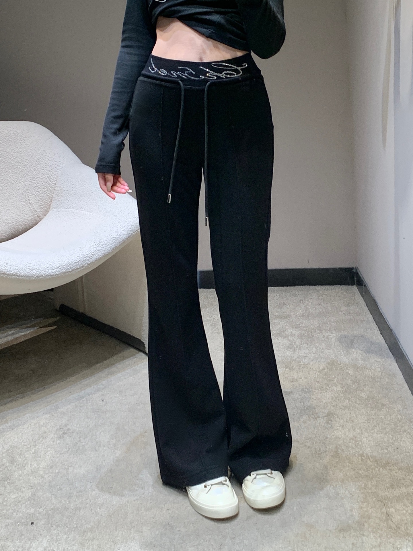 NO:697730,Cha*el 25Fw new autumn and winter style casual trousers with rhinestoned letter waistband | Exclusive high-end version!  The French elegance is interpreted in classic black and white colors. The hot-drilling process of the brand letters at the waist is the finishing touch. The Swarovski rhinestones are inlaid and arranged by hand, reflecting the delicate and bright luster under the light, showing the exquisite craftsmanship of the haute couture workshop. The matte knitted wool fabric is selected, and after brushing treatment, it feels soft and warm, with a drapey and elegant feel.  Shaping power; the high-waisted and slightly flared version cleverly raises the waistline, and the natural drape lines from the waist to the trouser legs modify the proportions of the legs. The loose trouser legs accommodate the leg shape and can be perfectly matched with short tops, sweaters and other items, injecting a lazy and high-end modern style into the autumn and winter looks. Available now in S/M/L,, swarovski,19860909Cha*el 25Fw秋冬新款 字母烫钻腰头休闲长裤丨独家高版出品！以经典黑白双色诠释法式奢雅,腰头处的品牌字母烫钻工艺堪称点睛之笔,施华洛世奇水钻经手工镶嵌排列,在光线下折射出细腻璀璨的光泽,尽显高定工坊的精湛匠艺.精选哑光针织羊毛面料,经磨毛处理后触感软糯温暖,兼具垂坠感与塑形力；高腰微喇版型巧妙拉高腰线,从腰腹到裤脚的自然垂坠线条修饰腿部比例,宽松裤管包容腿型的同时,又能与短上衣、针织衫等单品完美搭配,为秋冬造型注入慵懒又高级的摩登格调.现货发售S/M/L,,swarovski,,Women's clothing