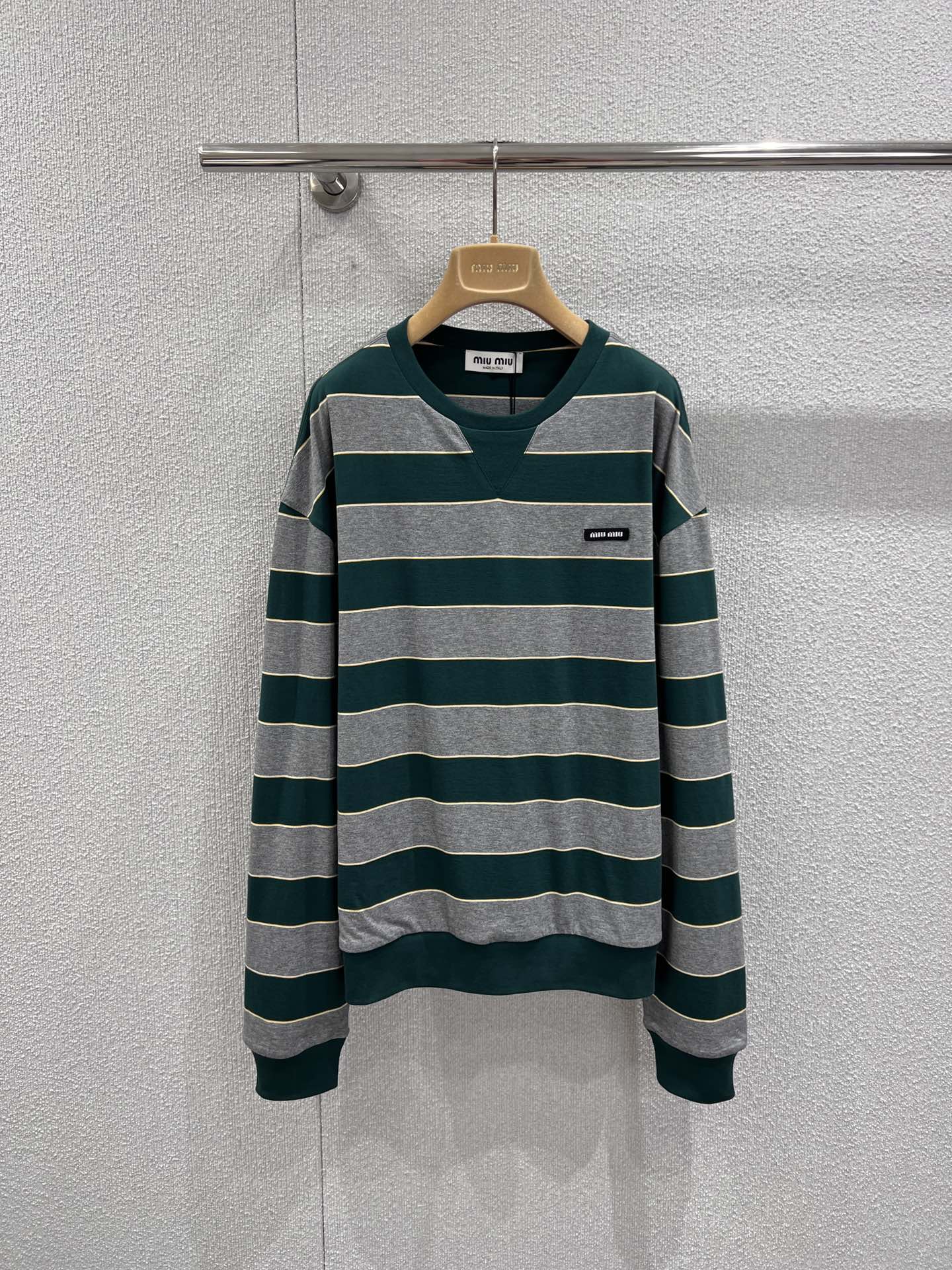 NO:709256,Support exchange MiuMi* 26Ss new early spring green striped round neck sweatshirt丨Exclusively developed by yb!  Top quality production!  Classic stripes are intertwined with retro dark green and soft ash, and are embellished with thin light yellow lines, adding a delicate luster to the basic model. The heavy cotton inner and outer double-layer fabric is both soft and skin-friendly and has a stiff silhouette. The oversize version hides flesh and is lazy, and the mini logo on the chest low-key highlights the brand recognition. Whether it is layered with a white shirt.  Whether you want to create a preppy style, or pair it with a short skirt and boots for a sweet and cool look, it can become a versatile and noble presence in your early spring wardrobe. Ready-made S/M/L real shot details,,miumiu,versace,boots,hoodie,sweatshirts,skirts,shirts,19860909支持换款 MiuMi* 26Ss早春新款 绿色条纹圆领卫衣丨独家yb开发！顶级高版出品！以复古墨绿与柔和烟灰交织出经典条纹,细闪的浅黄线条点缀其间,让基础款多了一份精致的光泽感.重磅棉里外双层面料兼具软糯亲肤与挺括廓形,Oversize的版型藏肉又慵懒,胸口的迷你徽标低调彰显品牌辨识度.无论是叠穿白衬衫打造学院风,还是搭配短裙与长靴诠释甜酷感,它都能成为早春衣橱里百搭又显贵的存在.现货发售S/M/L实拍细节图,,miumiu,versace,boots,hoodie,sweatshirts,skirts,shirts,,Women's clothing