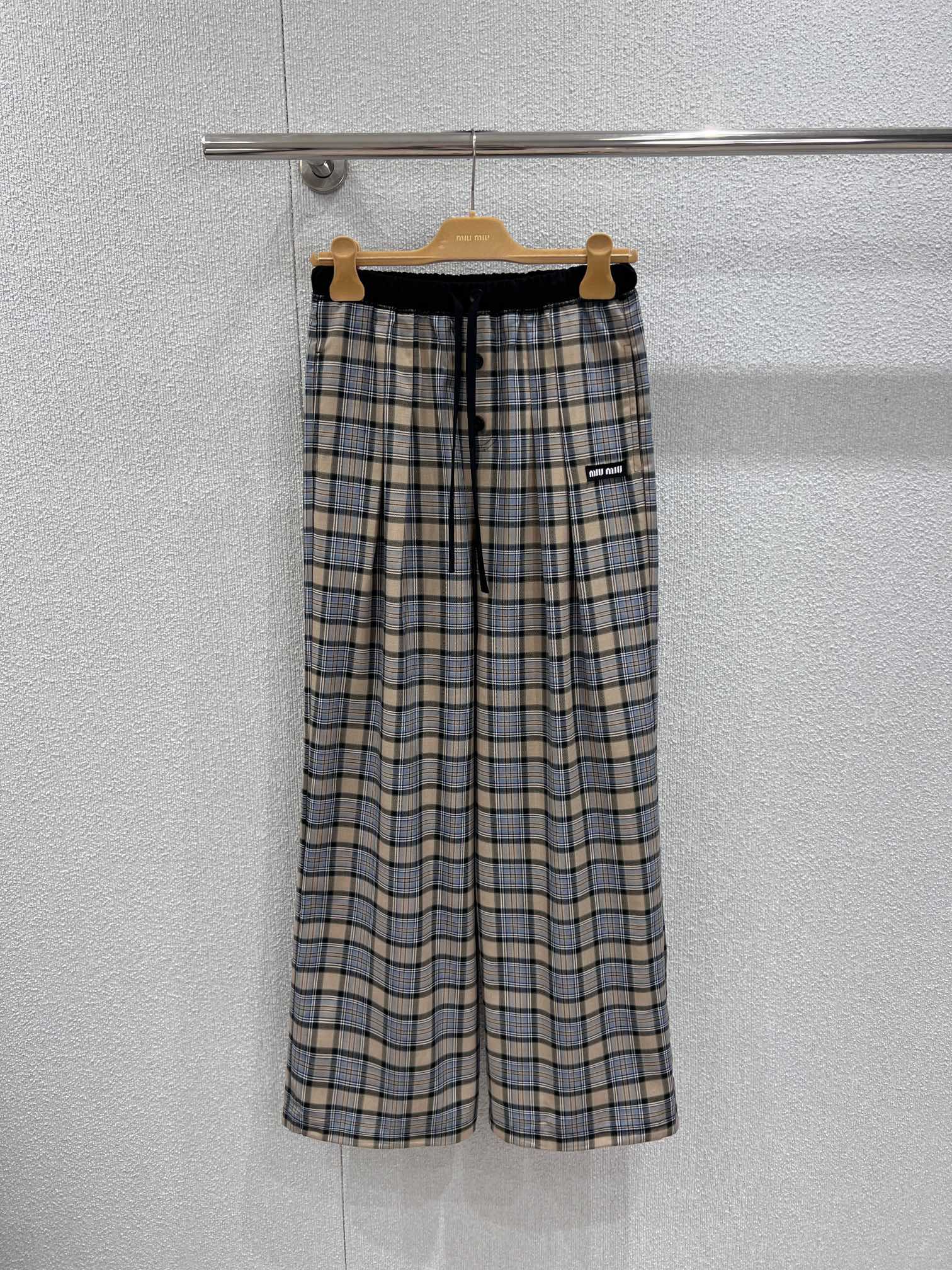 NO:710009,Support exchange MiuMi* 26Ss early spring series button plaid casual trousers丨Exclusive high-end version!  Selected high-count cotton fabrics, combined with light khaki bottom tone and navy blue plaid texture, with fine texture and outstanding drape; the waist is designed with elastic drawstring + buttons, which can adapt to different body shapes and add a layer of detail; the neat wide-leg tailoring naturally hangs from the waist and hips, weakening the leg lines and giving the outfit a lazy and relaxed atmosphere. Pants  The small brand logo on the side is a low-key finishing touch, perfectly integrating Miu's iconic girly sweetness and the casualness of early spring. Whether it is paired with a short sweater or a simple T-shirt, it can easily unlock high-end daily wear. Ready-made S/M/L real shot details, miumiu, tees, t-shirt,19860909支持换款 MiuMi* 26Ss早春系列 纽扣格纹休闲长裤丨独家高版出品！精选高支棉质面料,糅合浅卡其底调与藏蓝格纹纹理,肌理细腻且垂坠感出众；腰间采用松紧抽绳+纽扣双重设计,适配不同身形的同时,增添细节层次；利落的阔腿剪裁从腰胯自然垂落,弱化腿部线条的同时,赋予穿搭慵懒松弛的氛围.裤身侧边的品牌标识小标低调点睛,将Miu标志性的少女甜酷与早春的随性自在完美融合,无论是搭配短款针织衫还是简约T恤,都能轻松解锁高阶日常穿搭.现货发售S/M/L实拍细节图,,miumiu,tees，t-shirt,,Women's clothing