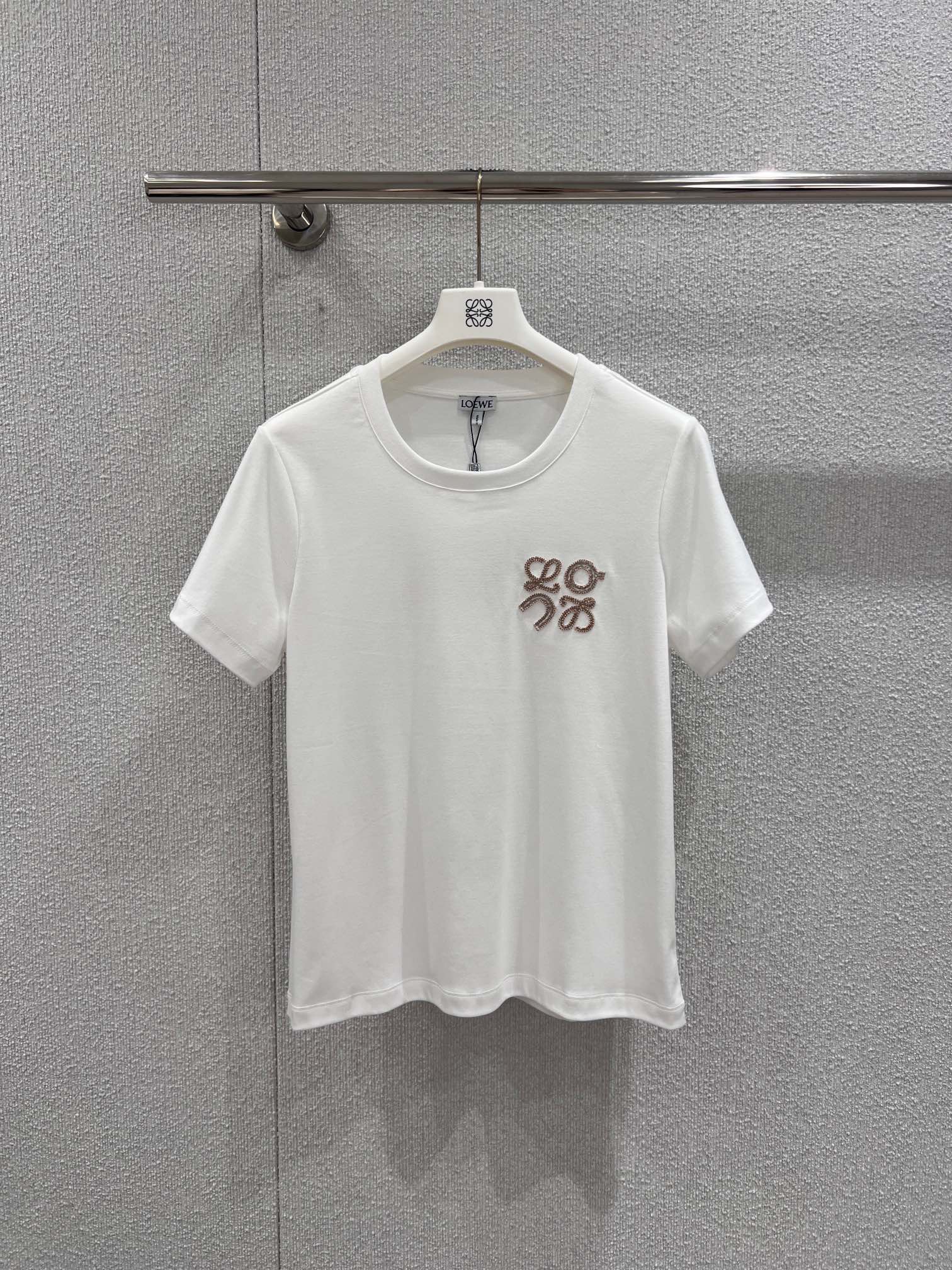 NO:710521,Support exchange Loew* 26Ss new early spring logo embroidered round neck short-sleeved T-shirt丨Exclusive high-end version!  Selected high-thread count pure cotton fabric, soft and delicate to the touch, yet stiff, close to the skin and breathable, perfect for early spring wear. The Anagram embroidery logo on the chest is the finishing touch of the design, using three-dimensional embroidery technology, the texture is full and three-dimensional, classic black and white, round neck cut to fit the neck line, slightly loose  The style is extremely tolerant to various body shapes. Whether worn alone to create a casual daily look, this T-shirt can become a versatile item in the early spring wardrobe with its low-key luxury. Ready for sale S/M/L real shot details, loewe, T-shirt, tees, t-shirt,19860909支持换款 Loew* 26Ss早春新款 logo刺绣圆领短袖T恤丨独家高版出品！精选高支数纯棉面料,触感柔软细腻且兼具挺括度,贴身穿戴亲肤透气,完美适配早春的穿着需求.胸前的Anagram刺绣标识是设计的点睛之笔,采用立体绣线工艺,纹理饱满立体,经典黑白两色,圆领剪裁贴合颈部线条,微宽松的版型对各种身形都有极好的包容度.无论是单穿打造随性的日常造型,这件T恤都能以低调的奢华感,成为早春衣橱里的百搭刚需单品.现货发售S/M/L实拍细节图,,loewe,T-shirt,tees，t-shirt,,Women's clothing