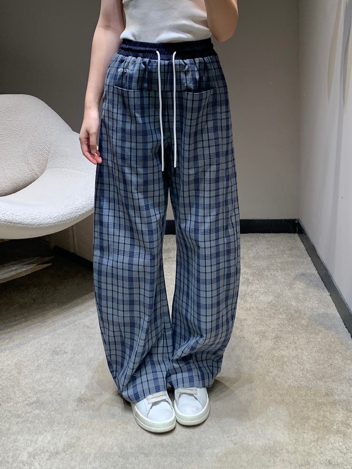 NO:712992,Miu Mi* 26Ss early spring new style contrasting waist drawstring plaid scimitar casual pants丨Exclusive high-end version!  The classic blue plaid replicates the retro college atmosphere. The intertwined dark and light plaid textures are rich in texture and bring a fresh early spring atmosphere; the contrasting waistband design is a visual highlight, with the navy ribs and plaid fabrics in sharp contrast. The white drawstring adds smart details and easily breaks the dullness of the plaid. The scimitar trousers are three-dimensional and the curved lines of the trouser legs fit the contours of the legs. The loose silhouette accommodates various leg types and drape when walking.  It is full of sense and can cleverly lengthen the leg lines. The fabric is made of light cotton blended material, which is soft, breathable and not easy to wrinkle. It is perfectly suitable for the wearing needs of early spring. Whether it is paired with a simple knitted vest or a casual short sweatshirt, it can become an eye-catching item for daily styling with its unique sweet and cool tone. Available in stock S/M/L,, miumiu, hoodie, sweatshirts,19860909Miu Mi* 26Ss早春新款 撞色腰头抽绳格纹弯刀休闲裤丨独家高版出品！经典的蓝调格纹复刻复古学院氛围,深浅交织的格纹纹理层次丰富,自带清新的早春气息；撞色腰头设计是视觉亮点,藏青罗纹与格纹面料形成鲜明对比,白色抽绳增添灵动细节,轻松打破格纹的沉闷.弯刀裤型采用立体剪裁,裤腿的弧形线条贴合腿部轮廓,宽松的廓形包容各种腿型,行走间垂坠感十足,还能巧妙拉长腿部线条.面料选用轻薄的棉混纺材质,柔软透气且不易皱,完美适配早春的穿着需求,无论是搭配简约的针织背心还是休闲的短款卫衣,都能以独有的甜酷腔调,成为日常造型的吸睛单品.现货发售S/M/L,,miumiu,hoodie,sweatshirts,,Women's clothing