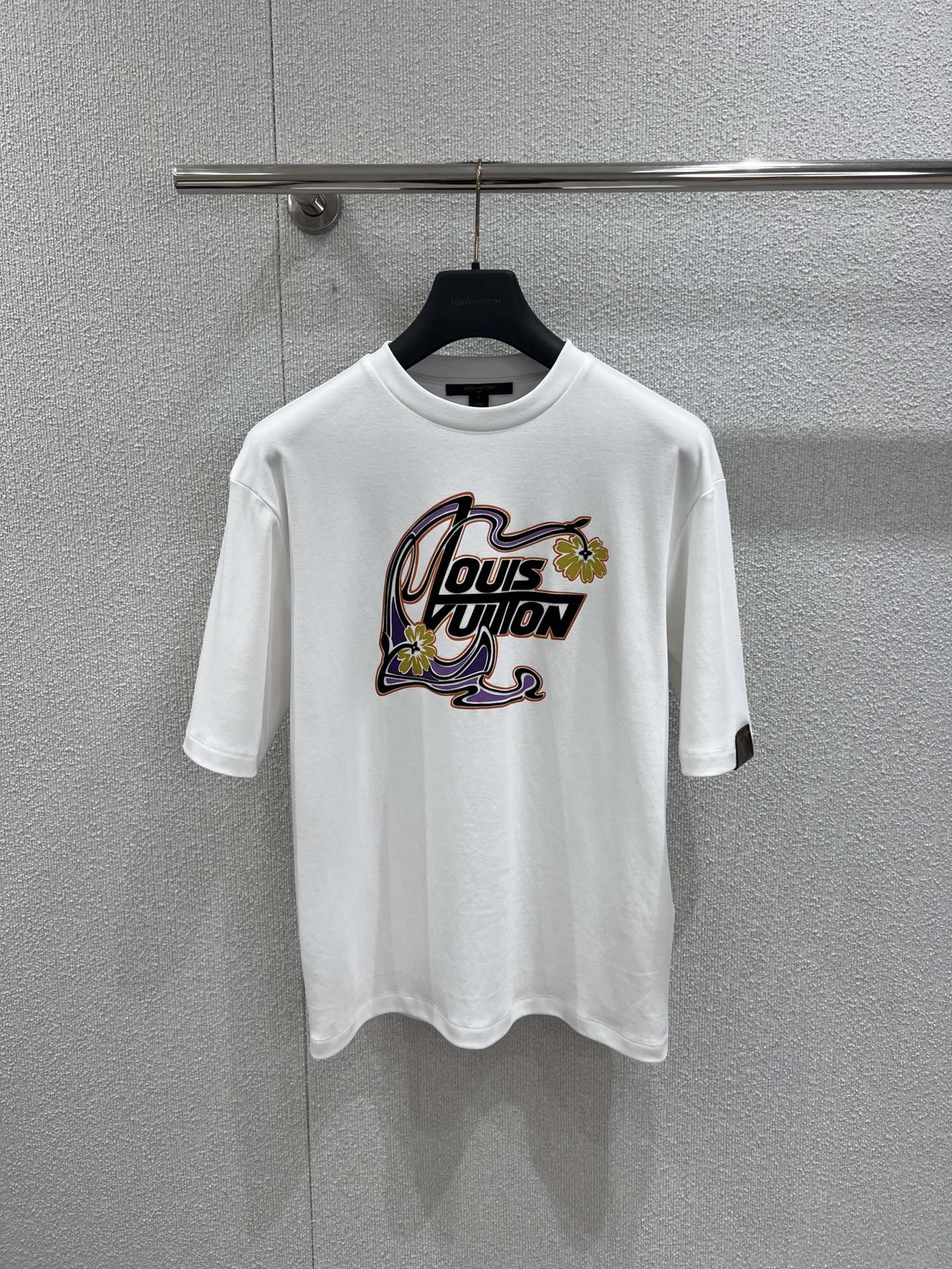 NO:713756,Support exchange Louis Vuitt*n 26Ss new early spring flower print round neck short-sleeved T-shirt丨exclusively developed by yb!  Top quality production!  The printed pattern on the chest outlines the logo with flowing lines and is embellished with bright yellow flowers, which breaks the stereotype of traditional logos and is particularly eye-catching in spring wear. The heavy cotton fabric gives the T-shirt an excellent silhouette. The loose round neck version is suitable for various body shapes, and the dropped shoulder design creates a casual and lazy atmosphere. Pair it with overalls to create a casual street style, and with a plaid skirt to unlock a sweet and cool girly look. A T-shirt can be used to play with various outfits in early spring!  Ready-made S/M/L real shot details, Louis Vuitton, skirts, T-shirt, tees, t-shirt,19860909支持换款 Louis Vuitt*n 26Ss早春新款 花朵印花圆领短袖T恤丨独家yb开发！顶级高版出品！胸前的印花图案以流动线条勾勒标识,明黄花朵点缀其间,打破了传统Logo的刻板印象,在春日穿搭中格外吸睛.重磅纯棉面料赋予T恤极佳的廓形感,宽松的圆领版型适配各种身形,落肩设计则营造出随性的慵懒氛围.搭配工装裤可打造率性街头风,配格纹半裙则解锁甜酷少女感,一件T恤即可玩转早春多元穿搭！现货发售S/M/L实拍细节图,,louis vuitton,skirts,T-shirt,tees，t-shirt,,Women's clothing