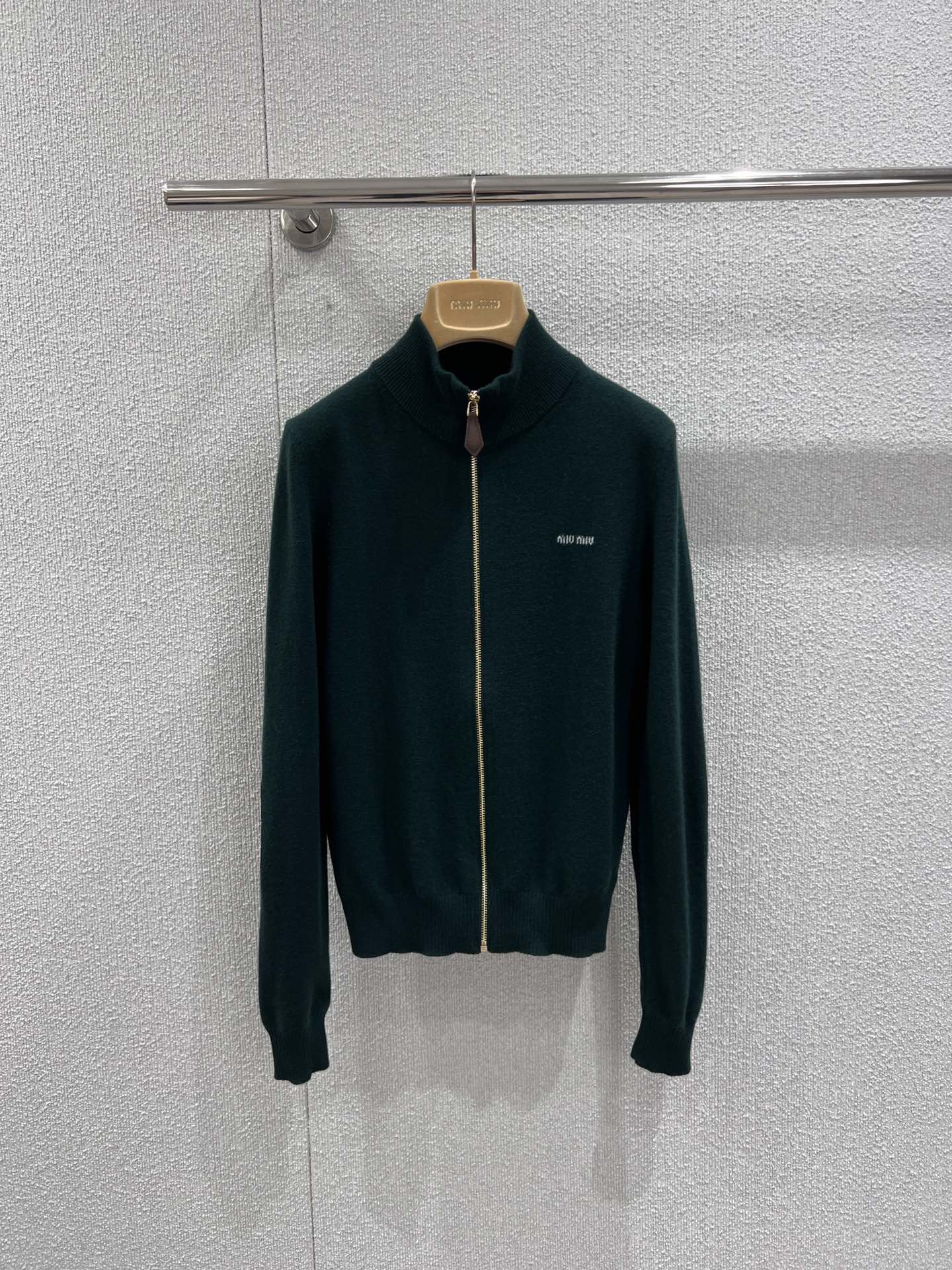 NO:713754,Support exchange MiuMi* 25Fw early autumn new dark green zipper stand collar cashmere knitted cardigan丨Exclusively developed by yb!  High quality production!  Made of high-luxury cashmere fabric, it feels as soft and waxy as clouds, has both warmth retention and skin-friendly properties. It is elegant and high-end when worn alone in early autumn, and can also hold texture firmly when layered in late autumn. The stand-up collar zipper design is neat and retro, and the metal zipper contrasts sharply with the dark green cashmere.  ,The exquisite MiuMiu brand logo on the chest shows off the identity in a low-key manner, and the splicing details on the elbows are hidden ingenuity, easily achieving the high-end girly feeling of retro and sweet cool. Ready-made S/M/L real shot details,,miumiu,19860909支持换款 MiuMi* 25Fw早秋新款 墨绿色拉链立领羊绒针织开衫丨独家yb开发！高版出品！采用高奢山羊绒面料,触感软糯如云朵,保暖性与亲肤性兼具,早秋单穿优雅高级,深秋叠穿也能稳稳承托质感.立领拉链设计利落又复古,金属拉链与墨绿色羊绒形成鲜明对比,胸前精致的MiuMiu品牌标识低调彰显身份,肘部的拼接细节更是暗藏巧思,轻松拿捏复古与甜酷交织的高级少女感.现货发售S/M/L实拍细节图,,miumiu,,Women's clothing