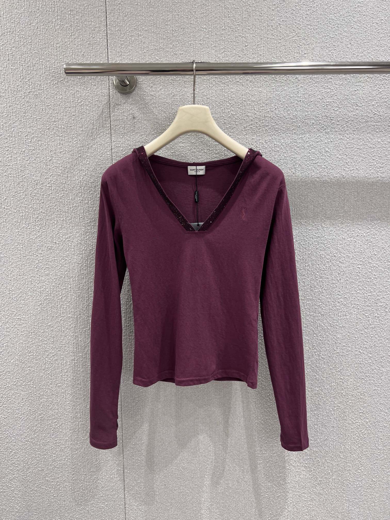 NO:713791,Support exchange of Saint laur*nt 26Ss early spring new letter embroidered V-neck hot diamond hooded long-sleeved bottoming shirt | Exclusive high-end version!  The low-saturation plum purple has its own gentle filter, making the skin tone even and translucent. The hot diamond embellishment on the edge of the V-neck reflects the fine luster under the light, hiding a sense of luxury in a low-key manner; the letter embroidery on the chest is an iconic identity mark, simple but highly recognizable.  Classy. The hooded design adds a bit of casualness, and the soft and skin-friendly fabric fits the body shape but is not tight. It can be worn alone to create a pure sexy style, or it can be worn as an inner layer with suits and coats. It is a rare all-purpose base for early spring wardrobes. Available now.  S/M/L real shot details,,saint laurent,business suit,hats,19860909支持换款 Saint laur*nt 26Ss早春新款 字母刺绣V领烫钻连帽长袖打底衫丨独家高版出品！低饱和的梅子紫自带温柔滤镜,衬得肤色匀净透亮.V领边缘的烫钻点缀在光线下折射出细碎光泽,低调中暗藏奢华感；胸前的字母刺绣是标志性的身份印记,简约却极具辨识度.连帽设计增添了几分随性休闲,软糯亲肤的面料贴合身形却不紧绷,既能单穿打造纯欲风,也能作为内搭适配西装、大衣,是早春衣橱里不可多得的万能打底.现货发售 S/M/L实拍细节图,,saint laurent,business suit,hats,,Women's clothing