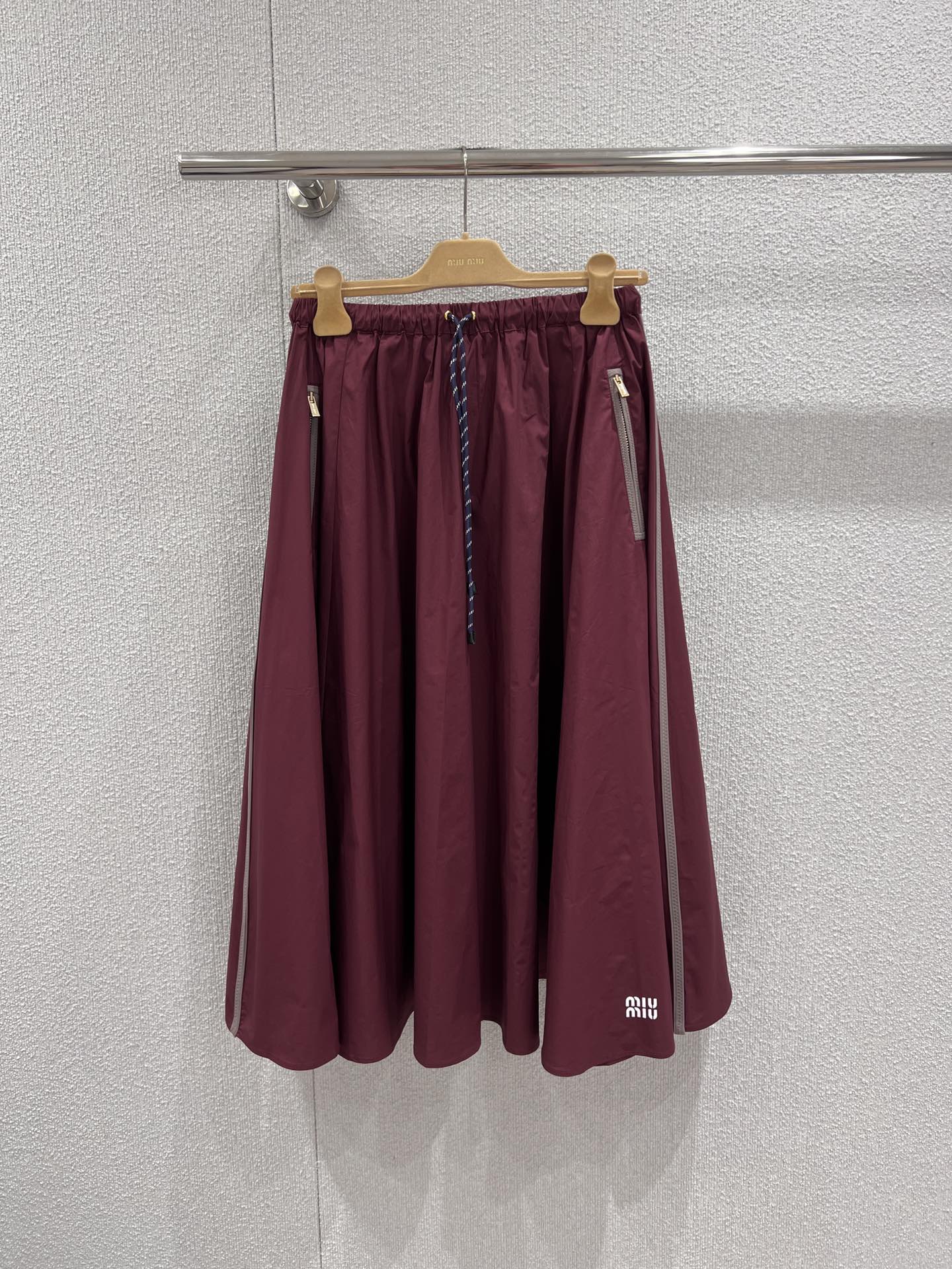 NO:715621,Support exchange Miumi* 26Ss early spring new style burgundy nylon zipper drawstring skirt丨exclusively developed by yb!  Top quality production!  The retro burgundy color is used as the base color to create a skirt with both a relaxed and girlish feel. The lightweight nylon fabric is crisp and smooth, and the oversized umbrella skirt has a romantic atmosphere. The skirt naturally drape and sway when you move around. The side zipper and drawstring waistband are both functional and designed, and can be adjusted to fit the body shape; the skirt body  Embellished with the iconic logo, the identity is low-key. Whether it is a jacket from the same series to create a set, or paired with a sweater to interpret a sweet and cool style, it can be the finishing touch of the early spring look. Ready-made S/M/L real shot details,, miumiu, skirts, jackets  & coats,19860909支持换款 Miumi* 26Ss早春新款 酒红色尼龙拉链抽绳半身裙丨独家yb开发！顶级高版出品！以复古酒红色为基调,打造兼具松弛感与少女感的半身裙.轻盈尼龙面料挺括垂顺,超大伞裙版型自带浪漫氛围感,走动间裙摆自然垂坠摇曳.侧边拉链与抽绳腰头兼具功能性与设计感,可随心调节松紧适配身形；裙身点缀标志性的徽标,低调彰显身份.无论是同系列外套打造成套穿搭,还是搭配针织衫诠释甜酷风格,都能成为早春造型的点睛之笔.现货发售S/M/L实拍细节图,,miumiu,skirts,jackets & coats,,Women's clothing