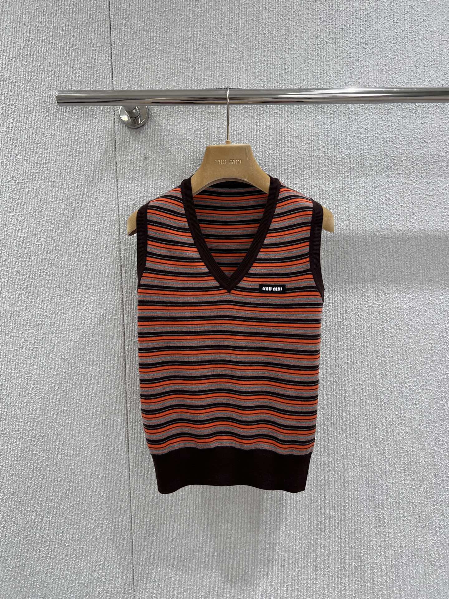 NO:717069,Support exchange Miu Mi* 26Ss early spring new style contrast striped wool V-neck vest sweater丨Exclusively developed by yb!  Top quality production!  This vest is designed with retro contrasting stripes as the core. Vibrant orange, dark brown, and gray and black are intertwined to create a distinct visual hierarchy, accurately echoing the fusion trend of college style and retro sports style this season. The V-neck and waist cut are neat and slim, and the fine wool material is both skin-friendly and stiff. Whether worn alone or as a layered inner layer, it can easily create a sweet and cool girly look. Ready-made S/M/L real shot details, miumiu,19860909支持换款 Miu Mi* 26Ss早春新款 撞色条纹羊毛V领背心针织衫丨独家yb开发！顶级高版出品！这款背心以复古撞色条纹为核心设计,活力橙与深棕、灰黑交织出鲜明视觉层次,精准呼应本季学院风与复古运动风的融合趋势.V领与收腰剪裁利落显瘦,细腻羊毛材质兼具亲肤感与挺括度,无论是单穿还是作为叠穿内搭,都能轻松塑造甜酷兼具的少女感.现货发售S/M/L实拍细节图,,miumiu,,Women's clothing