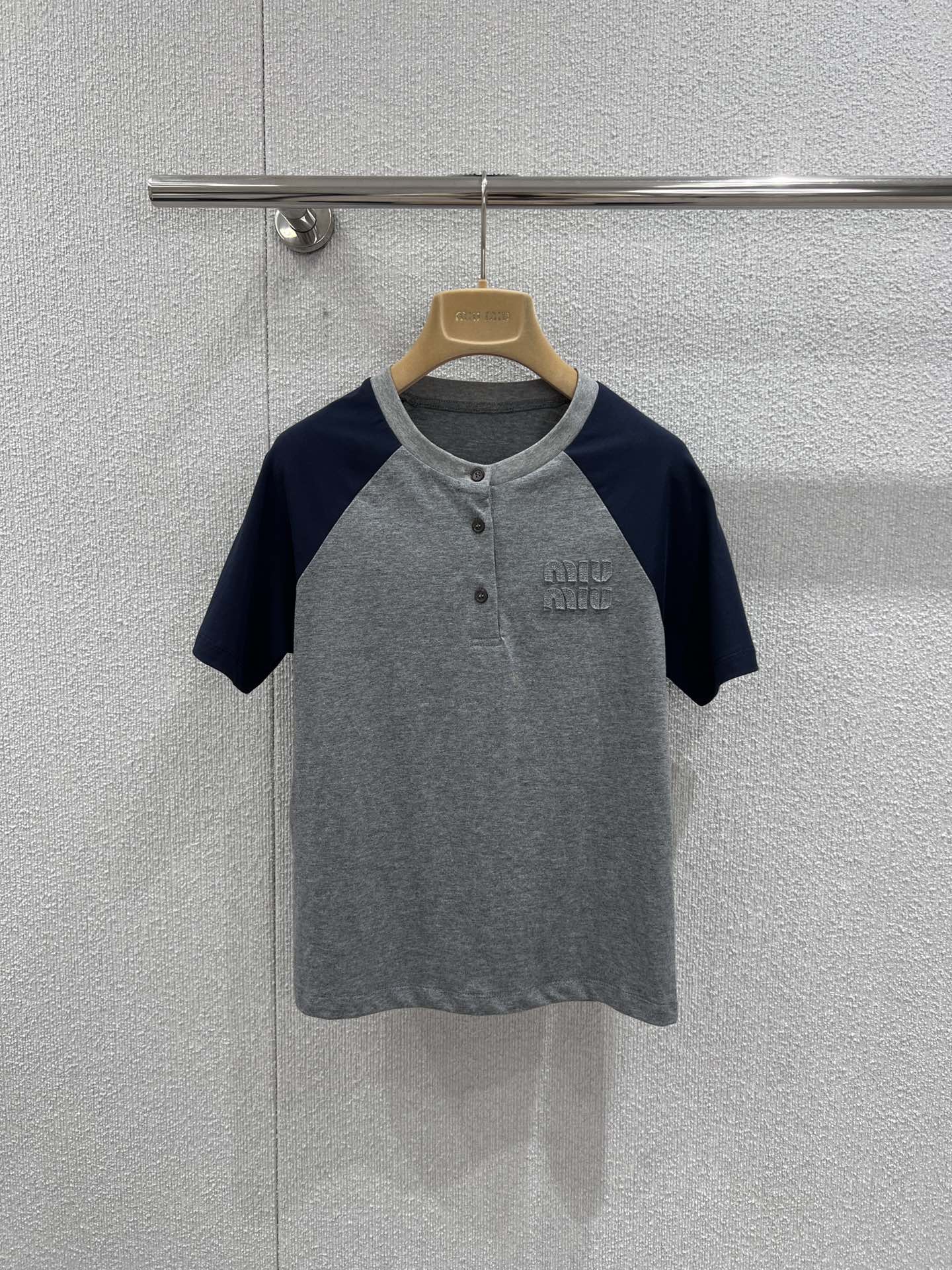 NO:717469,Support exchange Miu M*u 26Ss early spring new style patch embroidered logo casual color block round neck short-sleeved T-shirt丨Exclusively developed by yb!  Top quality production!  Based on the retro college style, the classic raglan sleeve design is integrated into daily items. The gray and blue contrasting colors are refreshing and neat, with a relaxed and youthful atmosphere; the three-dimensional appliqué logo on the chest is a low-key finishing touch, and the delicate texture enhances the overall texture. The soft cotton blended fabric is both comfortable and crisp, and the fit is tailored to fit the body shape.  But it’s not tight. Paired with white wide-leg pants, it has a casual commuting style. Paired with a pleated skirt, it can create a sweet and cool girly look. It is a versatile style that can be worn in the early spring wardrobe. Ready-made S/M/L real shot details, miumiu, skirts, T-shirt, tees, t-shirt,19860909支持换款 Miu M*u 26Ss早春新款 贴布绣logo休闲拼色圆领短袖T恤丨独家yb开发！顶级高版出品！复古学院风为基调,将经典插肩袖设计融入日常单品.灰蓝撞色清爽利落,自带松弛的青春氛围感；胸前立体贴布绣Logo低调点睛,细腻的纹理感提升了整体质感.柔软的棉混纺面料兼具舒适度与挺括感,合身剪裁贴合身形却不紧绷,搭配白色阔腿裤是随性通勤风,配百褶裙又能演绎甜酷少女感,是早春衣橱里实穿度拉满的百搭款.现货发售S/M/L实拍细节图,,miumiu,skirts,T-shirt,tees，t-shirt,,Women's clothing