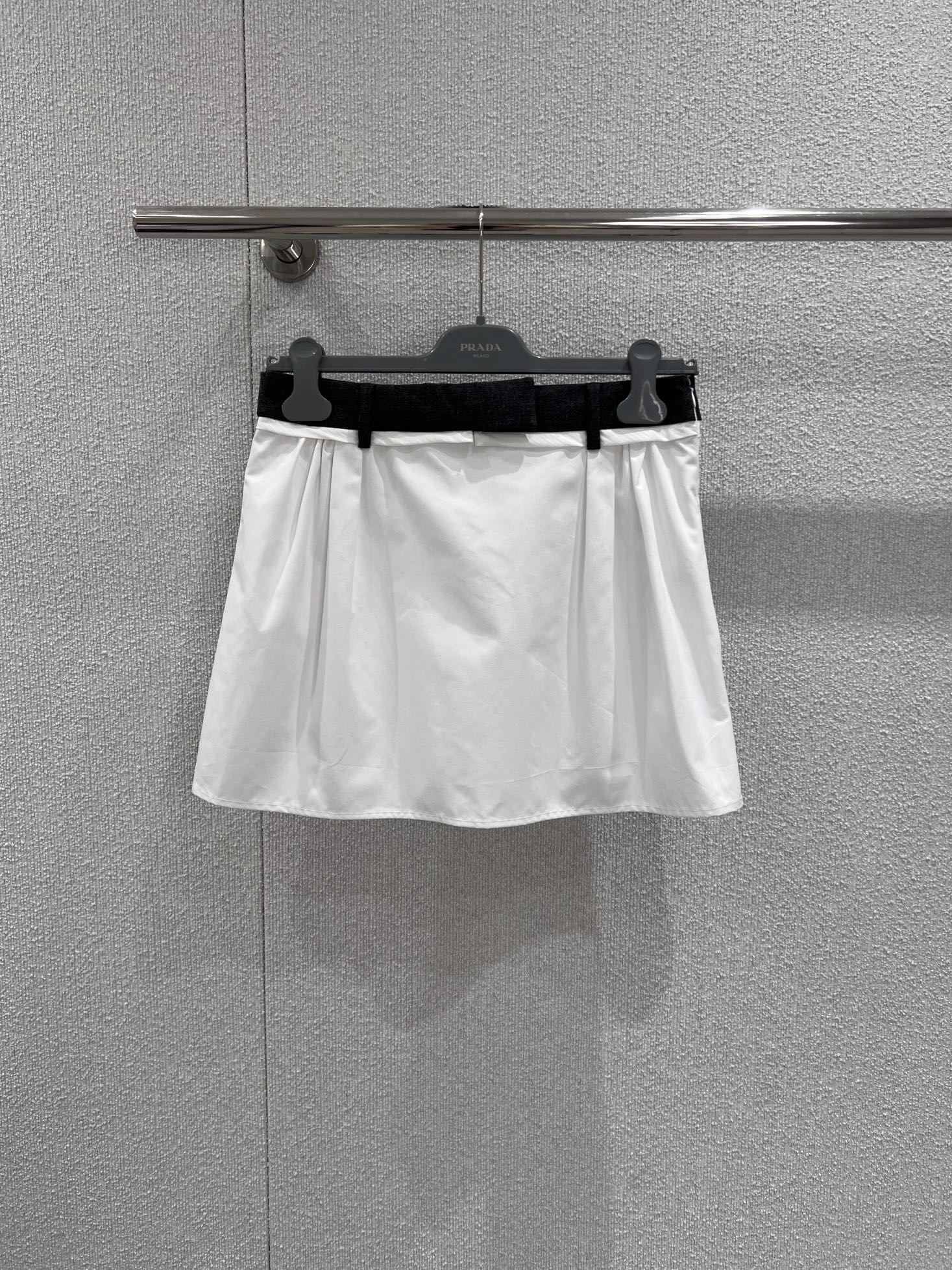 NO:717458,Supports exchange. Prad* 26Ss early spring new style. Stitched waist pleated white skirt | Exclusively developed by yb!  Top quality production!  The skirt is made of crisp cotton fabric, with a natural drape. The neat A-line silhouette is very tolerant to the body and can subtly modify the waist and hip lines. The iconic spliced waist design uses dark gray ribbons to form a visual contrast with the pure white skirt, hiding the brand's iconic details; the side pleats and drawstring elements add a relaxed and casual atmosphere and can be adjusted freely.  The skirt is elastic. Whether it is worn with a contrasting sweater to create a sweet and cool girl style, or worn with a striped Polo shirt and a jacket to create a retro college style, it can be the finishing touch in the look. It is a core item in the early spring wardrobe that has both a high-end feel and practicality. Ready-made S/M/L real shot details, prada, skirts, jackets  & coats,19860909支持换款 Prad* 26Ss早春新款 拼接腰头褶皱白色半身裙丨独家yb开发！顶级高版出品！裙身采用挺括的棉质面料,自带自然垂坠感,利落的A字廓形对身材包容度极高,能巧妙修饰腰臀线条.标志性的拼接腰头设计,以深灰色织带与纯白裙身形成视觉对比,暗藏品牌标志性的细节巧思；侧边褶皱与抽绳元素则增添了松弛随性的氛围感,可自由调节裙身松紧.无论是搭配撞色针织衫打造甜酷少女风,还是内搭条纹Polo衫叠穿夹克演绎复古学院风,都能成为造型中的点睛之笔,是早春衣橱里兼具高级感与实穿性的核心单品.现货发售S/M/L实拍细节图,,prada,skirts,jackets & coats,,Women's clothing