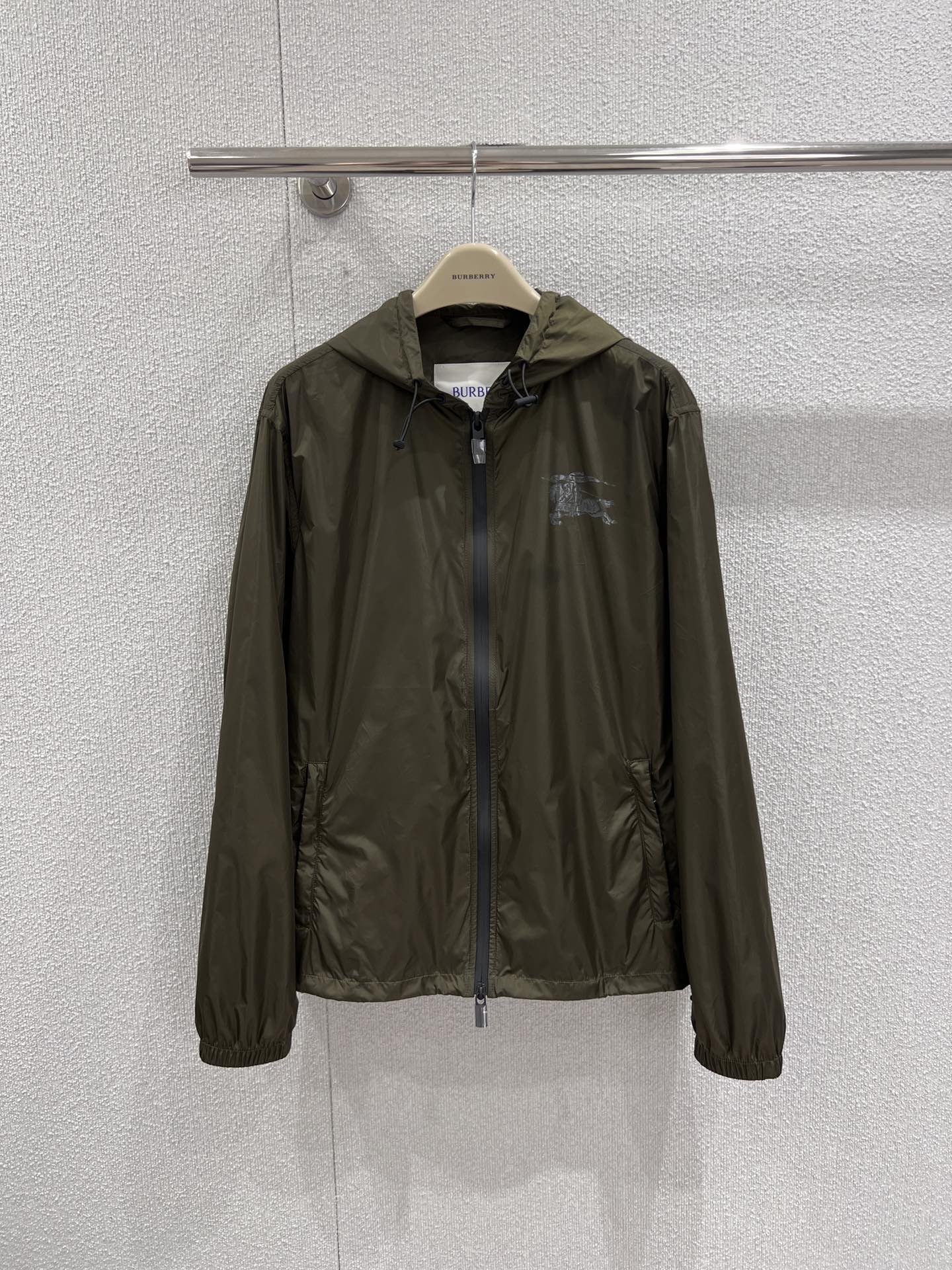 NO:740545,Support exchange Burberr* 26Ss early spring new equestrian rider logo nylon jacket丨Exclusive high-end version!  It is made of lightweight waterproof nylon fabric to create a practical texture. The iconic equestrian knight logo is embellished on the chest and back with hot silver technology, injecting classic elements into the minimalist silhouette. The loose hooded version has both windproof functionality and a relaxed atmosphere. It can be worn alone to create a casual street style, or can be layered with a sweater to adapt to the temperature difference in early spring. It is a versatile style item in the wardrobe. Ready-made S/M/L real shot details, burberry, jackets &  coats, hats,19860909支持换款 Burberr* 26Ss早春新款 马术骑士徽标尼龙外套丨独家高版出品！以轻质防水尼龙面料打造实用质感,标志性马术骑士徽标采用烫银工艺点缀于胸前与后背,在极简廓形中注入经典元素.宽松连帽版型兼具防风功能性与松弛氛围感,可单穿打造随性街头风,也可叠穿针织衫适配早春温差,是衣橱里的百搭型格单品.现货发售S/M/L实拍细节图,,burberry,jackets & coats,hats,,Women's clothing