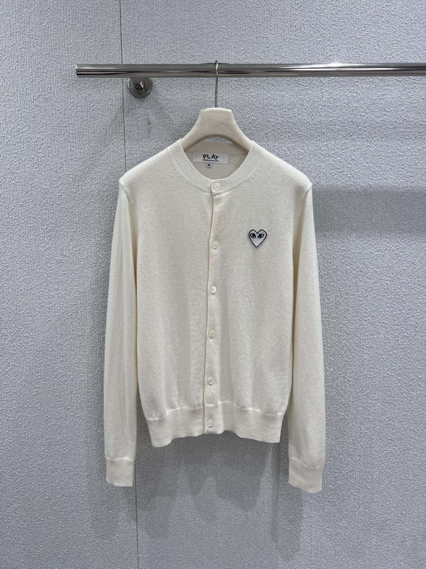 NO:734687,Support exchange PL*Y COM*E des GARC*NS 26Ss early spring series micro-label round neck wool knitted cardigan丨Exclusive high-end version!  With the iconic 'love + eyes' logo as the soul, it is embellished on the pure off-white wool knitted base, continuing the iconic minimalist and playful style. The fine wool blended fabric is selected, soft to the touch and skin-friendly, with both warmth and breathability. The round neck and single-breasted design are simple and neat, and the loose silhouette is suitable for all body types.  It is extremely inclusive. It can be worn alone to create a casual everyday feel, or it can be layered with a T-shirt or suspenders as a jacket. It is a versatile and easy-to-match classic item in the early spring wardrobe. Whether commuting or leisure, it can add a touch of iconic fun to the look. Ready-made S/M/L real shot details,,jackets  & coats,tees,t-shirt,19860909支持换款 PL*Y COM*E des GARC*NS 26Ss早春系列 微标圆领羊毛针织开衫丨独家高版出品！以标志性的“爱心+眼睛”徽标为灵魂,点缀在纯净米白的羊毛针织基底上,延续标志性的极简玩味风格.精选细腻羊毛混纺面料,触感柔软亲肤,兼具保暖性与透气性,圆领与单排扣设计简约利落,宽松廓形对各种身材都极具包容性.既可单穿打造随性日常感,也能作为外套叠穿T恤或吊带,是早春衣橱中百搭不挑人的经典单品,无论通勤还是休闲,都能为造型增添一抹标志性的趣味感.现货发售S/M/L实拍细节图,,jackets & coats,tees，t-shirt,,Women's clothing