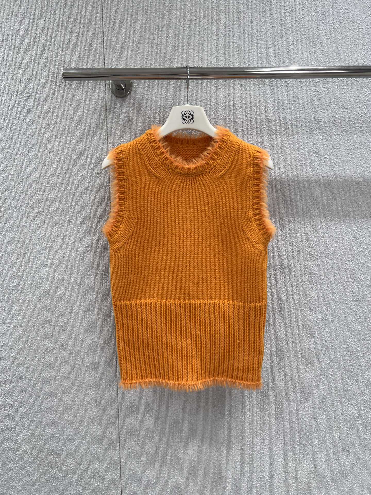 NO:734679,Supports exchange. Loew* 26Ss early spring series orange wool knitted vest丨exclusively developed by yb!  Top quality production!  It is based on a vibrant warm orange color, injecting bright vitality into early spring. It is made of soft and skin-friendly wool blended fabric, with a delicate knitted texture on the surface, which is both warm and breathable. The upper part is knitted with flat knitting, and the lower part is converted into a vertical pit strip waist design, which can cleverly outline the waistline, while the raw edge details on the collar, cuffs and hem  , adding a sense of casual relaxation to the whole. It can be layered with shirts to create a college style, or paired with a T-shirt or a suspender skirt to create a layered look. It is a versatile item in the early spring wardrobe to enhance the vitality of the look. Ready-made S/M/L real shot details, loewe, skirts, shirts, tees, t-shirt,19860909支持换款 Loew* 26Ss早春系列 橘色羊毛针织马甲丨独家yb开发！顶级高版出品！以充满活力的暖橘色为基调,为早春注入明媚生机.采用柔软亲肤的羊毛混纺面料,表面呈现细腻的针织肌理,兼具保暖性与透气性.上半部分为平针编织,下半部分转为竖坑条收腰设计,能巧妙勾勒腰线,同时领口、袖口与下摆处的毛边细节,为整体增添随性松弛感.既可叠穿衬衫打造学院风,也能搭配T恤或吊带裙塑造层次感,是早春衣橱中提升造型活力的百搭单品.现货发售S/M/L实拍细节图,,loewe,skirts,shirts,tees，t-shirt,,Women's clothing