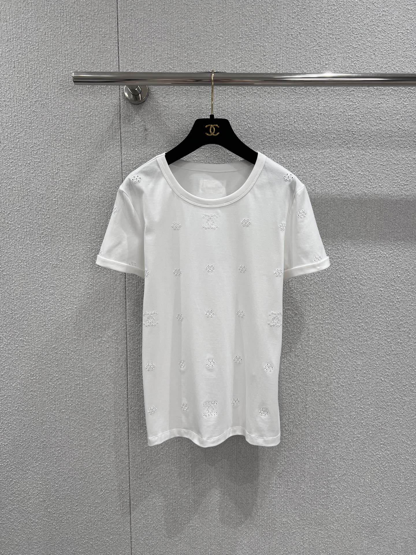 NO:735151,Support exchange Chane* 26C Advanced Handicraft Workshop Series New Hollow Flower Double C Embroidery Round Neck Short Sleeve T-shirt丨Exclusive high-end version!  Using minimalist pure white as the base, the iconic Double C logo and exquisite hollow flower embroidery are integrated into the body. The delicate hollow patterns are scattered and distributed, showing a looming and transparent texture under the light. The Double C embroidery is embellished among them, low-key and revealing the recognition. It is made of high-count cotton blended fabric, which has both silky drape and skin-friendly breathability, and is well-fitting and tailored.  With its slim figure, it can be paired with jeans for a casual everyday look, or with a skirt to create an elegant French style. It is an essential wardrobe item that can easily adapt to many scenes. Ready-made S/M/L real shot details, chanel, skirts, jeans, T-shirt, tees, t-shirt,19860909支持换款 Chane* 26C高级手工坊系列新款 镂空花朵双c刺绣圆领短袖T恤丨独家高版出品！以极简纯白为基底,将标志性的双C标识与精致镂空花朵刺绣融入衣身.细腻的镂空花纹错落分布,在光线下呈现若隐若现的通透质感,双C刺绣点缀其间,低调流露辨识度.选用高支棉混纺面料,兼具丝滑垂坠感与亲肤透气性,合身剪裁贴合身形线条,可搭配牛仔裤打造随性日常,也能配半裙诠释优雅法式风情,是一件能轻松适配多场景的衣橱刚需单品.现货发售S/M/L实拍细节图,,chanel,skirts,jeans,T-shirt,tees，t-shirt,,Women's clothing