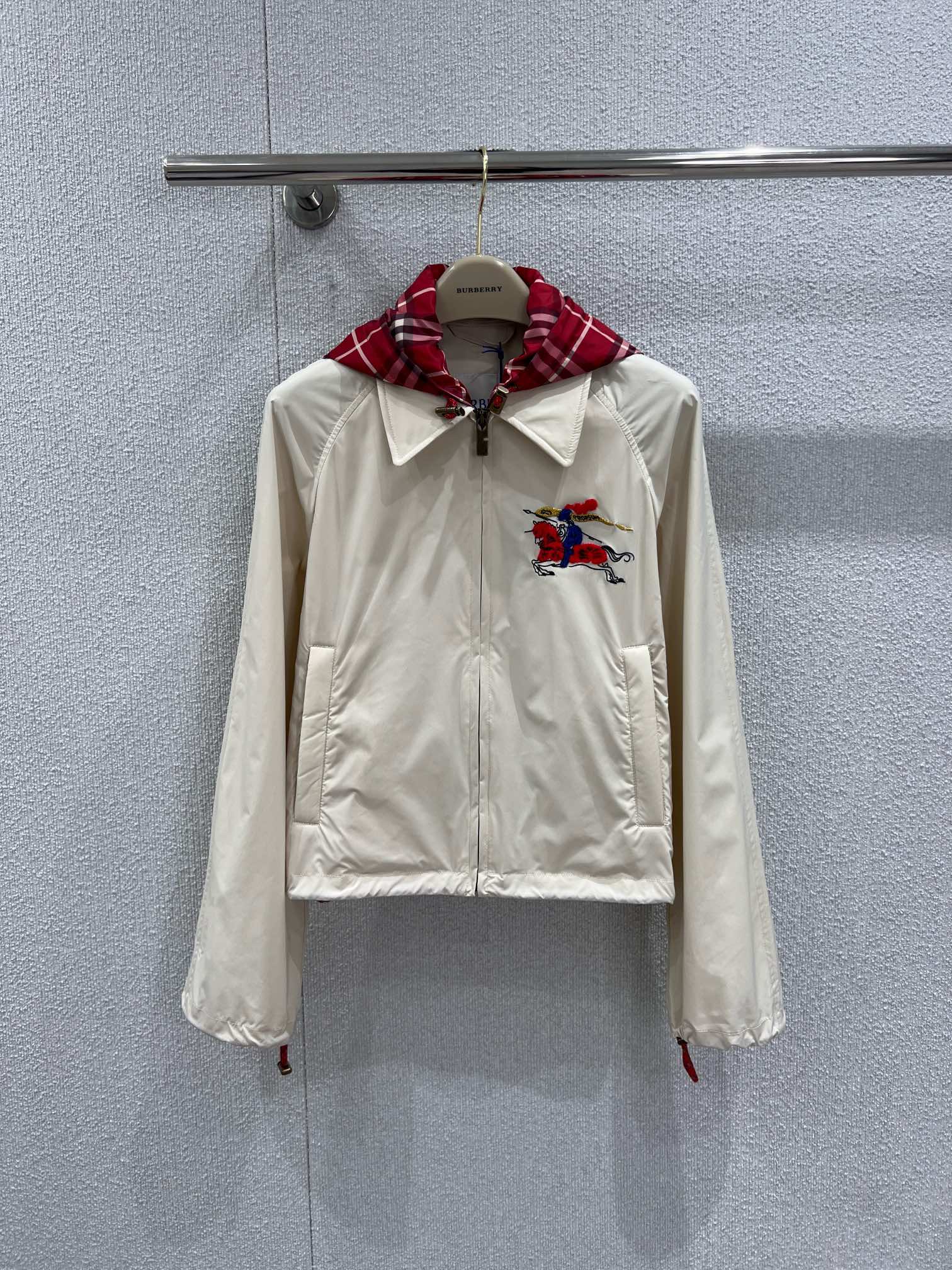 NO:736509,Supports exchange Burberr* 26Ss early spring New Year New Year series hooded short jacket丨Exclusively developed by yb!  High quality production!  The off-white base carries British genes. The iconic war horse embroidery appears on the left chest. The red and black plaid hooded lining hides classic details. The drawstring hem and elastic cuffs neatly outline the body shape. The lightweight windproof fabric is flexible and practical in spring, whether it is paired with the same style.  Whether it is a sweater or a denim item, it can be switched freely between daily life and occasions. It is the finishing touch of the new year's wardrobe that has both a sense of ceremony and practicality. Ready-made S/M/L real shot details, burberry, jackets  & coats,hats,19860909支持换款 Burberr* 26Ss早春新禧贺岁系列 连帽短款外套丨独家yb开发！高版出品！以米白基底承载英伦基因.标志性战马刺绣跃于左胸,红黑格纹连帽内衬暗藏经典细节,抽绳收摆与松紧袖口利落勾勒身形.轻量防风面料兼顾春日灵动与实用,无论是搭配同系列针织衫还是牛仔单品,都能在日常与场合间自如切换,是新岁衣橱里兼具仪式感与实穿性的点睛之笔.现货发售S/M/L实拍细节图,,burberry,jackets & coats,hats,,Women's clothing