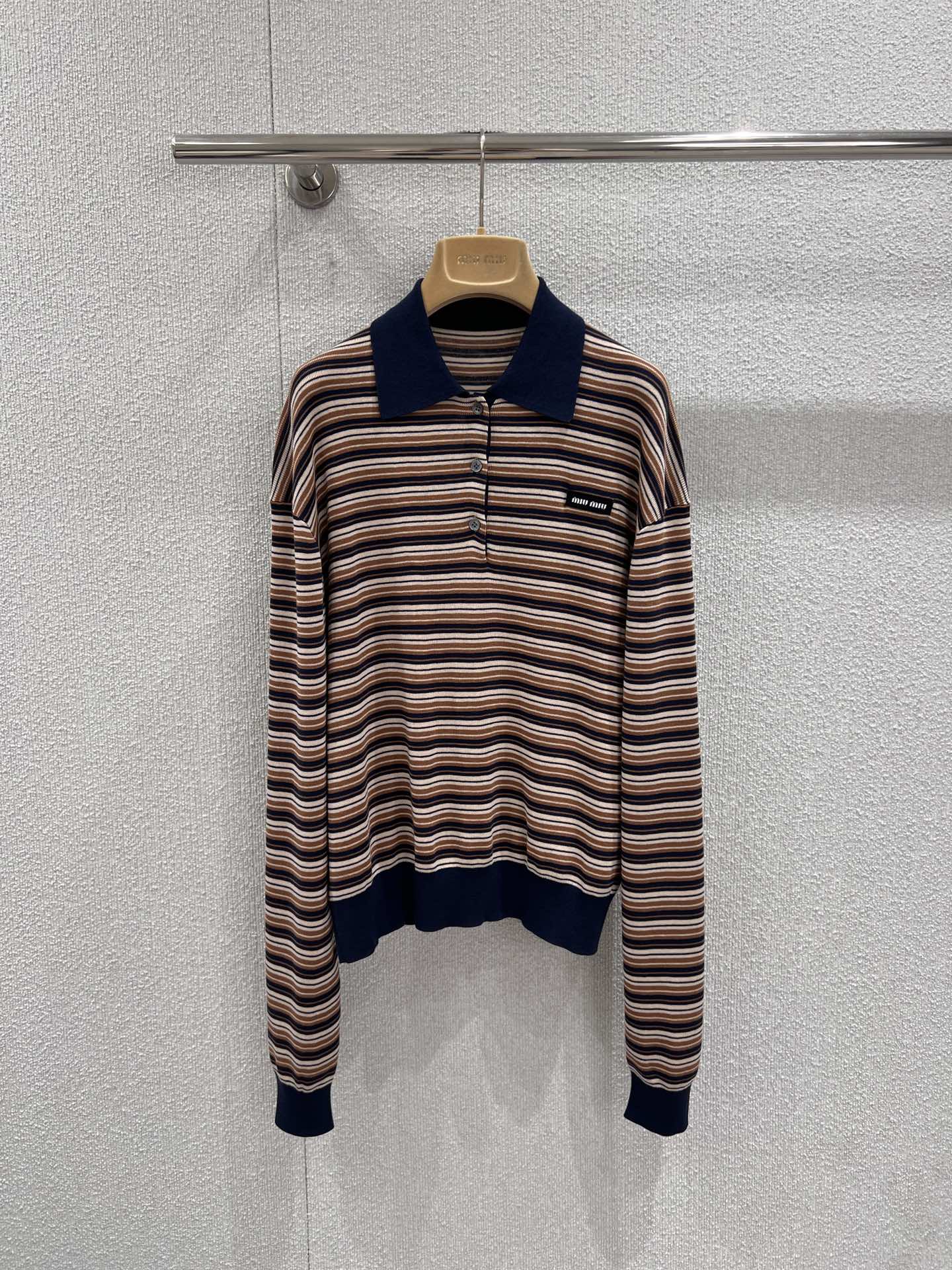 NO:736506,Support exchange Miu Mi* 26Ss early spring new brown striped wool knitted POLO shirt | Exclusively developed by yb!  Top quality production!  Selected fine wool fabric, soft and skin-friendly, both warm and breathable. The classic lapels, ribbed cuffs and hem outline neat lines, and the micro logo on the chest hides exquisite details. Brown, rice and navy blue stripes are interlaced. It comes with retro filters. The loose Oversize version accommodates all body types and can easily create a lazy and casual early spring look. Ready-made S/M/L real shot details, miumiu, versace,19860909支持换款Miu Mi* 26Ss早春新款 棕调条纹羊毛针织POLO衫丨独家yb开发！顶级高版出品！甄选细腻羊毛面料,触感软糯亲肤,兼具保暖与透气.经典翻领与罗纹袖口、下摆勾勒利落线条,胸前的微标暗藏精致细节,棕、米、藏青三色条纹交织,自带复古滤镜,宽松Oversize版型包容各种身材,轻松打造慵懒随性的早春造型.现货发售S/M/L实拍细节图,,miumiu,versace,,Women's clothing