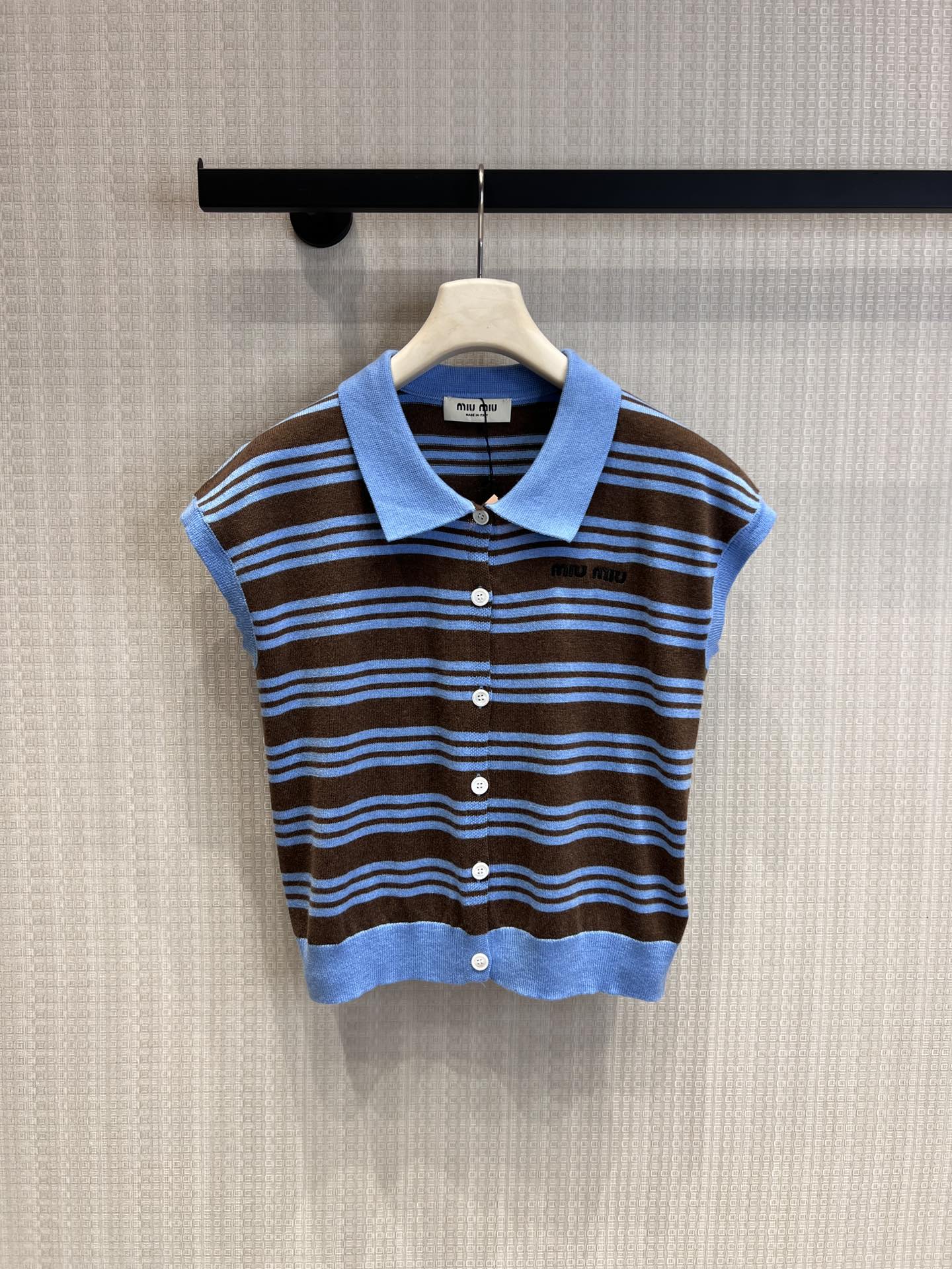 NO:751447,Support exchange Miu* 26Ss early spring new style simple striped Polo knitted vest cardigan丨Exclusive high-end version!  It cleverly combines retro stripes with modern tailoring. The contrasting stripes present a delicate texture on the knitted fabric. The Polo lapel and sleeveless design not only retain the classic college temperament, but also add a bit of casual relaxation. The front button opening makes the outfit more flexible, and the collarbone line is exposed when worn alone.  When layered, it can enrich the style. Whether it is paired with denim bottoms to create an American retro style, or combined with a skirt to create a sweet girl look, it can be easily held in place and become an eye-catching tool for you to go out in early spring. Ready-made S/M/L real shot details,, miumiu, skirts,19860909支持换款Miu* 26Ss早春新款 简约条纹Polo针织背心开衫丨独家高版出品！将复古条纹与现代剪裁巧妙融合.撞色条纹在针织面料上呈现出细腻的肌理感,Polo翻领与无袖设计,既保留了经典的学院气质,又增添了几分随性松弛.前襟纽扣开合,让穿搭更具灵活性,单穿时露出锁骨线条,叠穿时则能丰富造型层次.无论是搭配牛仔下装打造美式复古风,还是与半身裙组合成甜妹造型,都能轻松hold住,成为你早春出街的吸睛利器.现货发售S/M/L实拍细节图,,miumiu,skirts,,Women's clothing