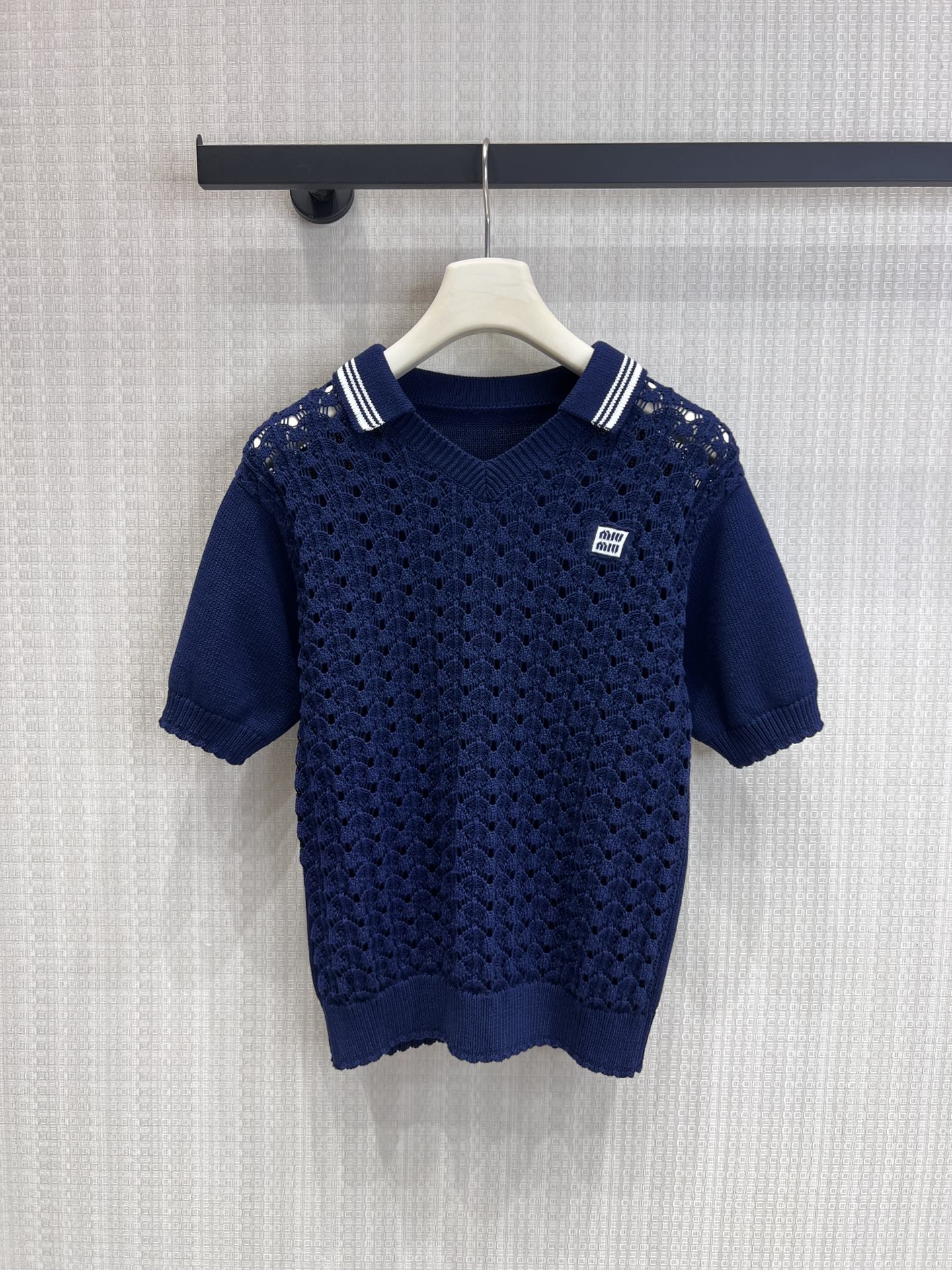 NO:762709,Support exchange Miu* 26Ss new spring and summer navy blue lapel carved hollow knitted polo short-sleeved top | Exclusively developed by yb!  Top quality production!  High-quality knitting yarns are selected, and the whole body is three-dimensionally carved with hollow craftsmanship, showing exquisite fish scale texture and excellent breathability. The classic V-shaped lapels are matched with contrasting striped piping to restore the retro college accent; the Miu* logo embroidery on the chest is low-key and recognizable.  The full-length, loose-shouldered silhouette modifies the arm lines, and the hem has a casual lace-up design. Pair it with shorts or skirts from the same series to easily create a relaxed feel. Miulook. A must-have for summer wardrobe, the light and luxurious hollow Polo brings elegance and vitality to the end!  Ready-made S/M/L real shot details, miumiu, skirts, shorts, T-shirt,19860909支持换款Miu* 26Ss春夏新款 海军蓝翻领雕花镂空针织polo短袖上衣丨独家yb开发！顶级高版出品！甄选高品质针织纱线,全身立体雕花镂空工艺,呈现精致鱼鳞纹理,透气性极佳.经典V型翻领搭配撞色条纹滚边,还原复古学院腔调；胸口Miu*徽标刺绣低调点缀,辨识度拉满.宽松落肩版型修饰手臂线条,下摆随性系带设计,搭配同系列短裤或半裙,轻松拿捏松弛感Miulook.夏日衣橱必备的轻奢镂空Polo,将优雅与活力进行到底！现货发售S/M/L实拍细节图,,miumiu,skirts,shorts,T-shirt,,Women's clothing