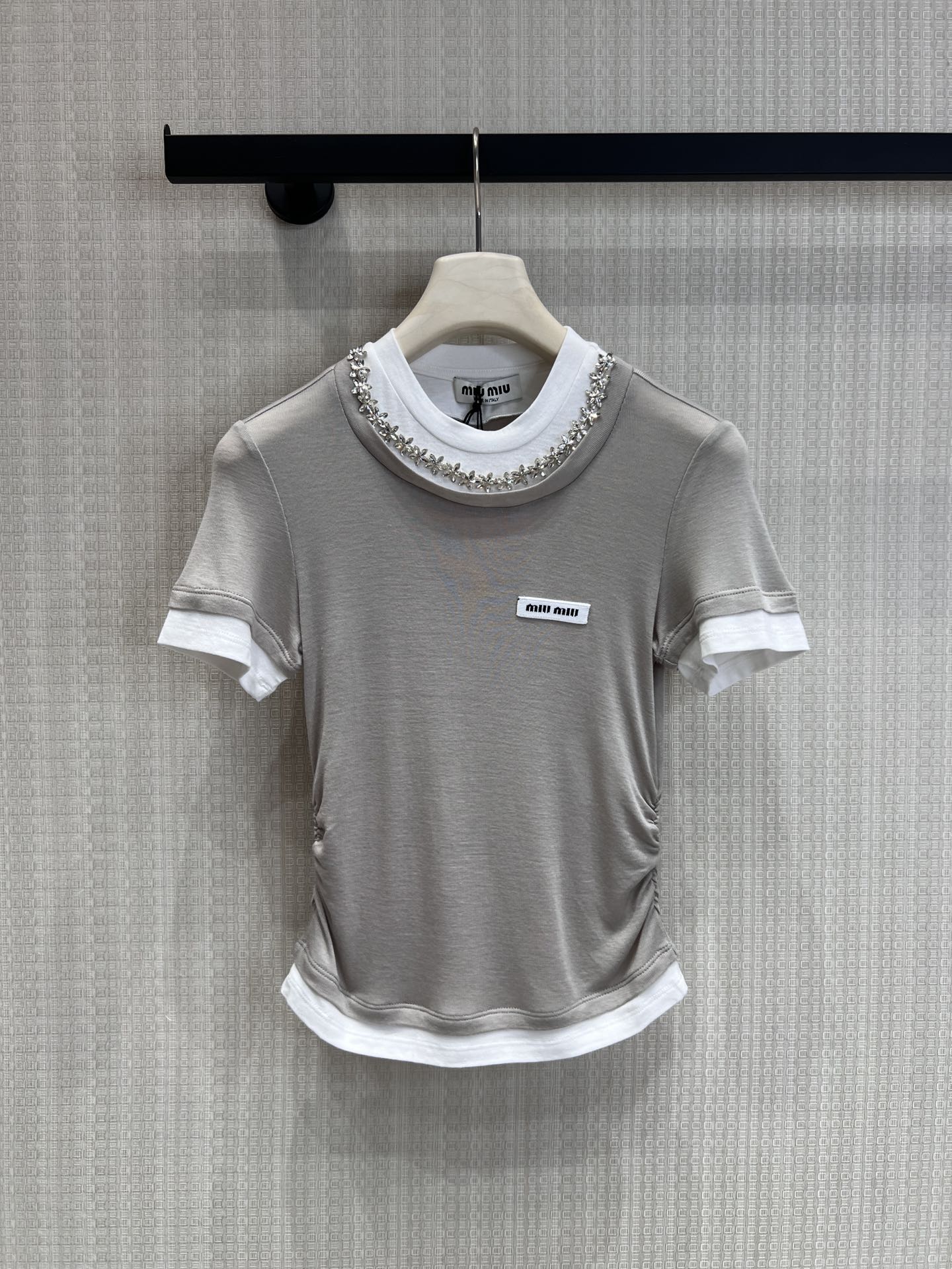 NO:759254,Support exchange Miu* 26Ss early spring new style micro-label diamond collar fake two-piece slim short-sleeved T-shirt | Exclusive high-end version!  The classic fake two-piece layering has a natural layering of white cuffs and hem, which is lazy and delicate; the neckline is inlaid with a circle of sparkling diamonds, which sparkles in the light, giving it the atmosphere of a rich family. The small label on the chest is low-key and imprinted with genes, unobtrusive but full of recognition. Ready-made S/M/L real shot details, miumiu, T-shirt, tees, t-shirt,19860909支持换款Miu* 26Ss早春新款 微标钻领假两件修身短袖T恤丨独家高版出品！经典假两件叠穿感,白边袖口与下摆自然层次,慵懒又精致；领口镶嵌满圈闪钻,在光线下细碎闪耀,自带富家千金氛围感.胸口小标低调印刻基因,不张扬却辨识度拉满.现货发售S/M/L实拍细节图,,miumiu,T-shirt,tees，t-shirt,,Women's clothing